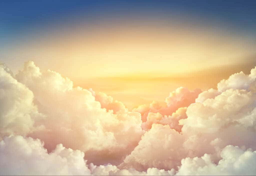 Beautiful Heaven 桌布 壁紙 — 日出時分，廣闊的蓬鬆雲朵在柔和藍天的映襯下閃耀著溫暖的金色光芒。