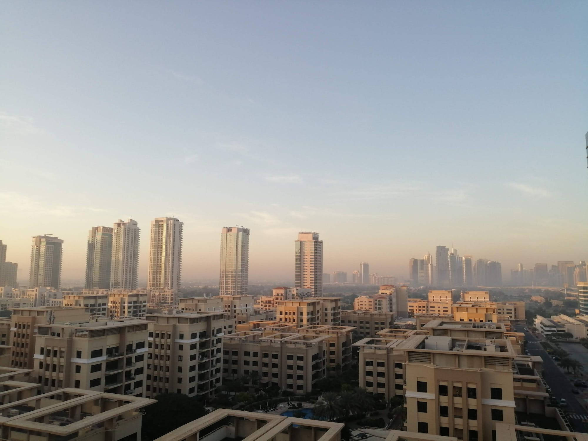 Morning 桌布 壁紙 — 日出為廣闊的城市天際線中的現代高層建築和較低住宅建築披上溫暖的光芒。