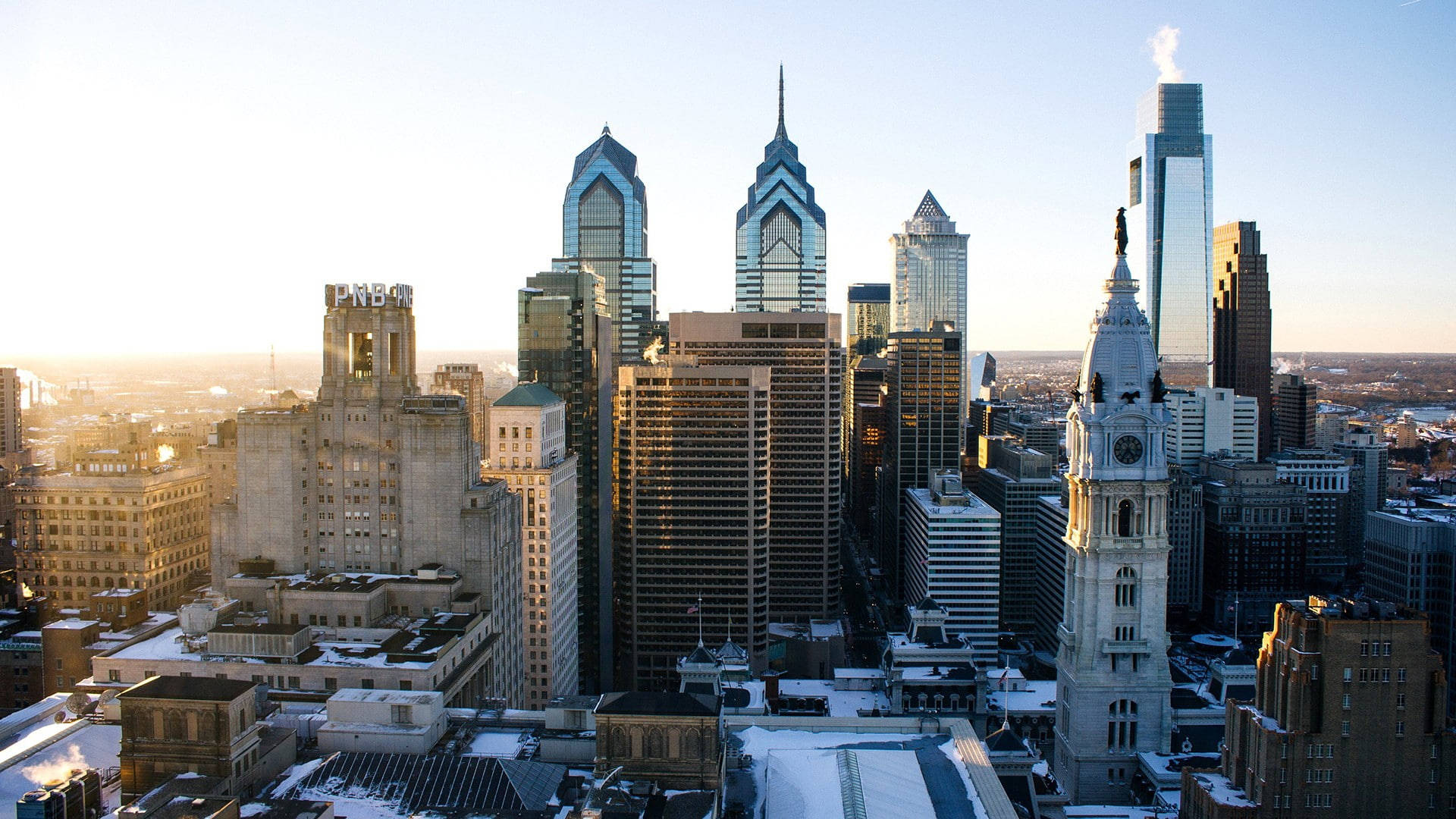 Philadelphia 桌布 壁紙 — 日出照耀著積雪的費城天際線，歷史悠久的鐘樓和玻璃摩天大樓。