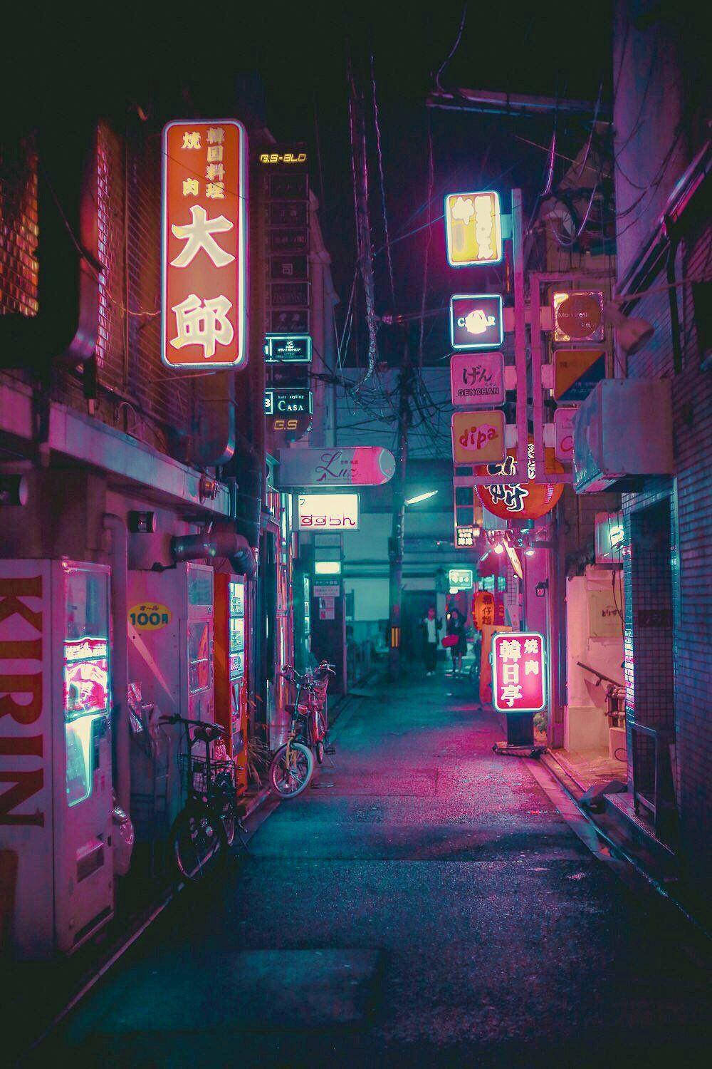 日本 桌布 壁紙 — 日本城市夜晚一條狹窄的霓虹燈小巷，有發光的招牌和停放的自行車。
