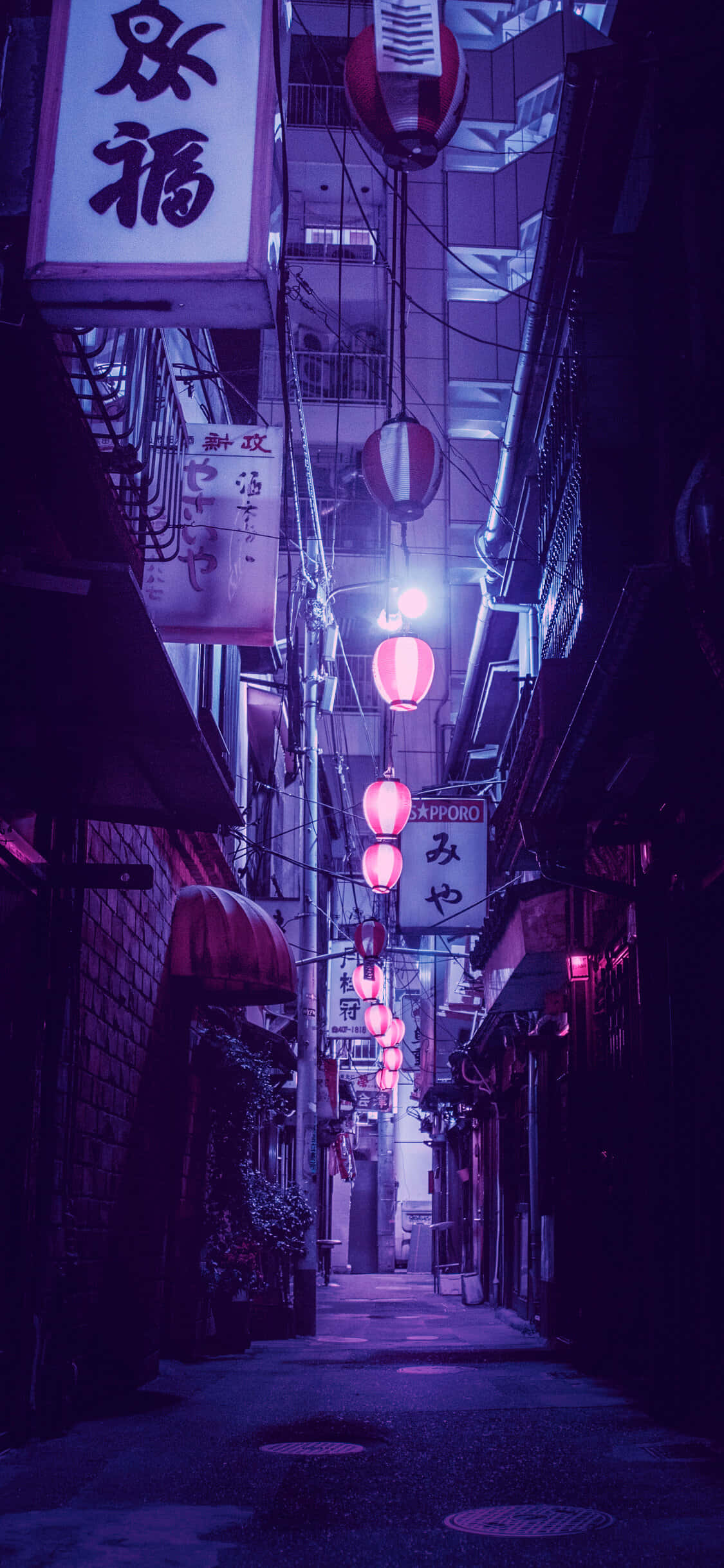 手機 桌布 壁紙 — 日本夜晚一條狹窄的霓虹燈小巷，發光的粉紅色燈籠和傳統招牌在潮濕的路面上投射出紫色色調。