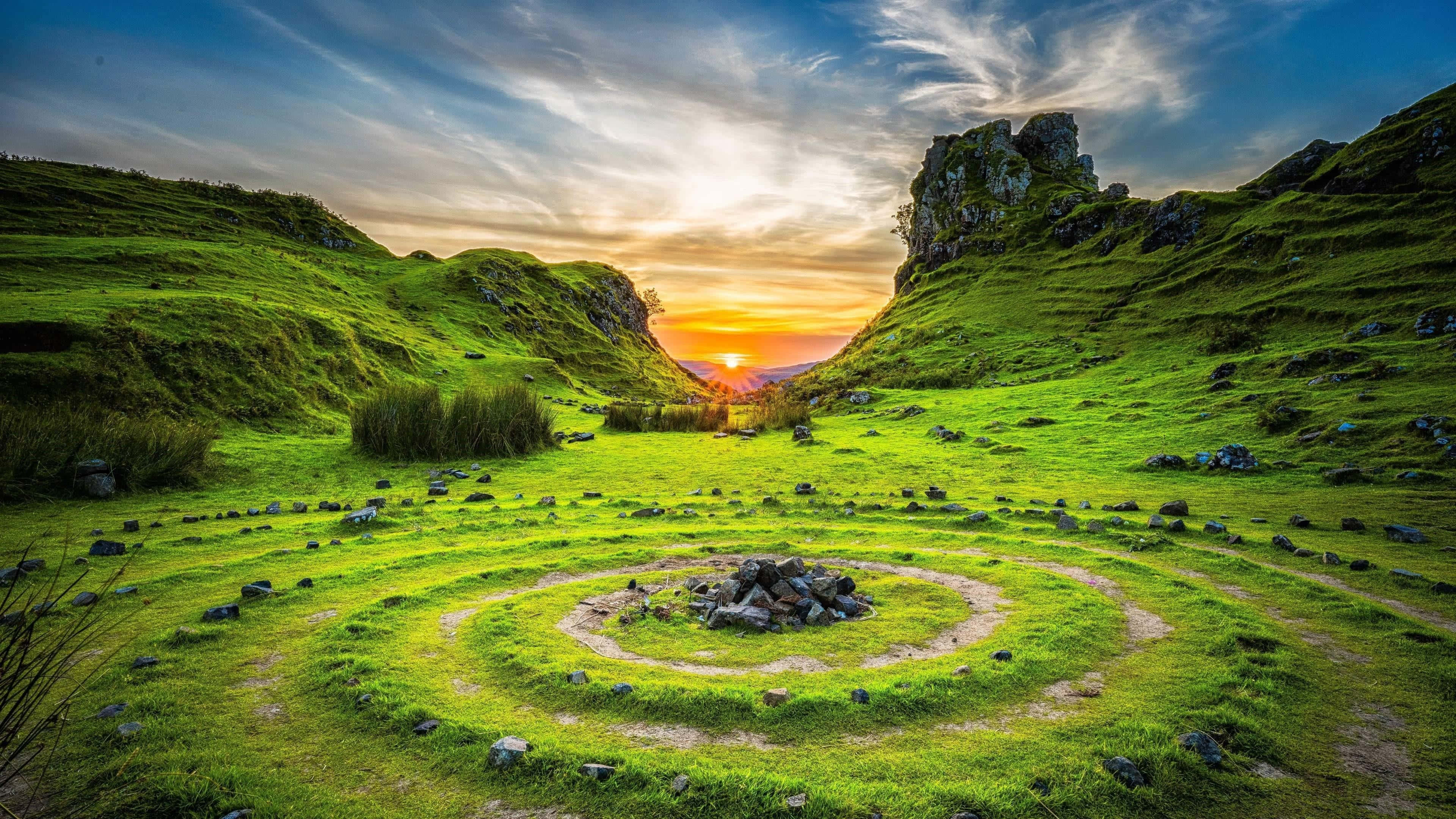 4K Ultra HD Landscape 桌布 壁紙 — 日落時分，一個充滿活力的綠色山谷中，有一條螺旋石徑通往岩石露頭，天空壯麗。