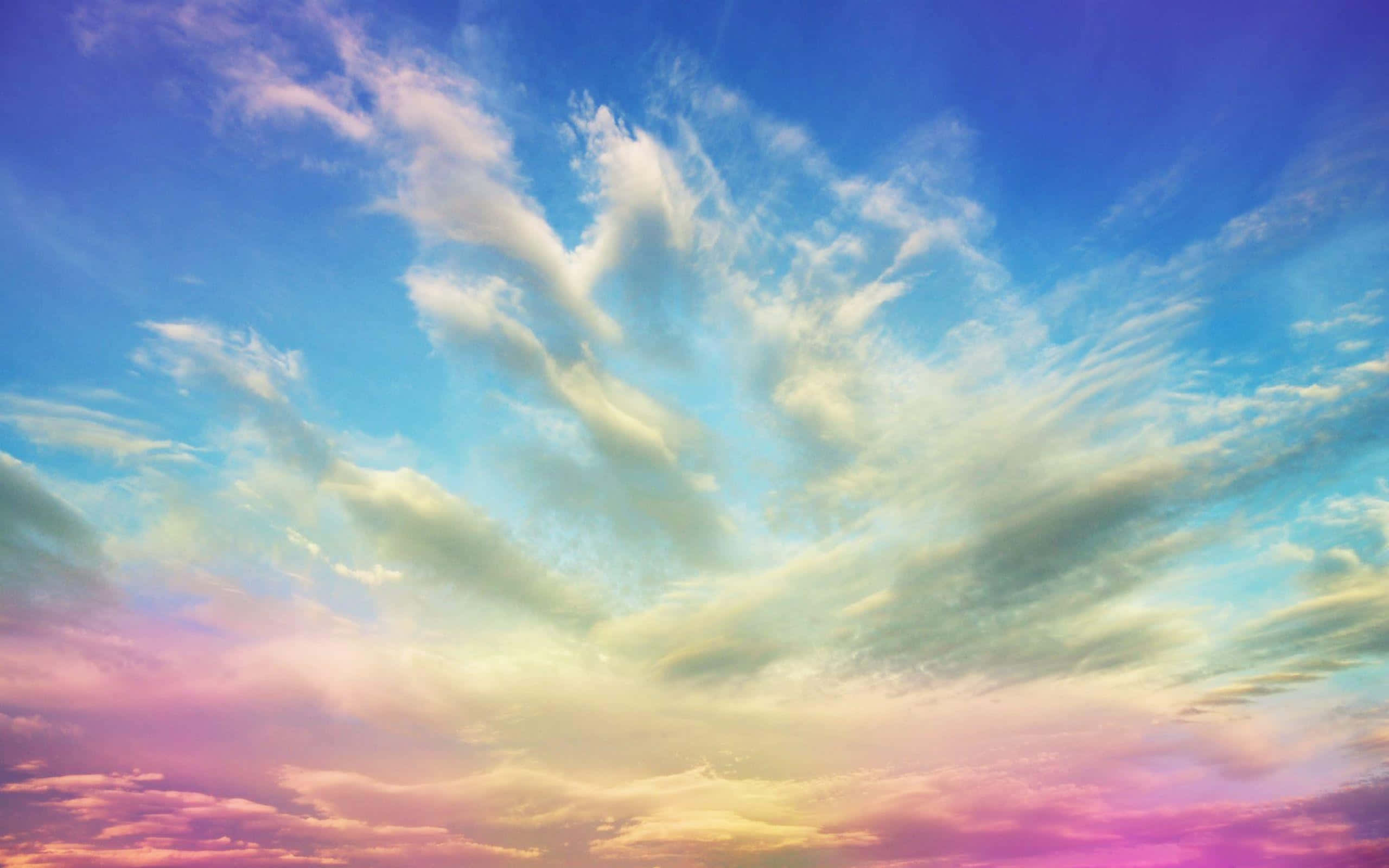 Sky Clouds 桌布 壁紙 — 日落時分，充滿活力的天空，薄雲在粉紅、黃和藍色調中發光。