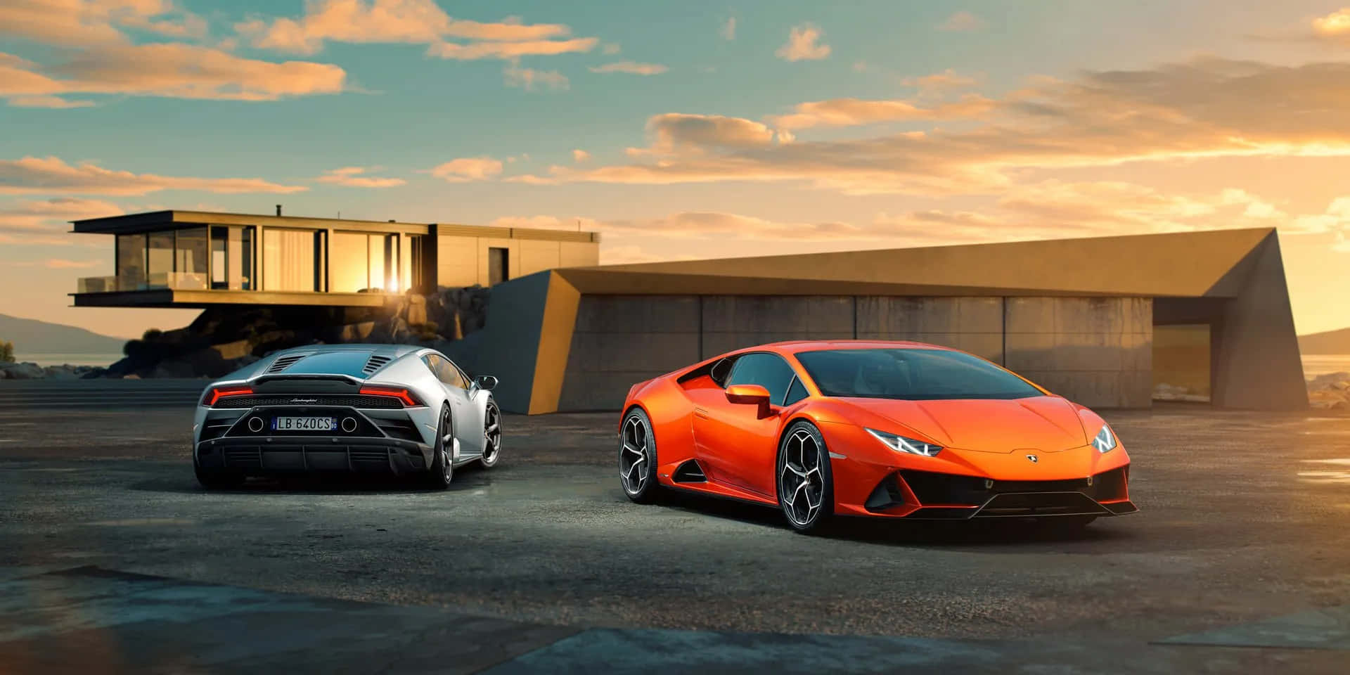 Cool Lamborghinis 桌布 壁紙 — 日落時分，兩輛銀色和橙色的藍寶堅尼跑車停在一棟現代混凝土房屋前。
