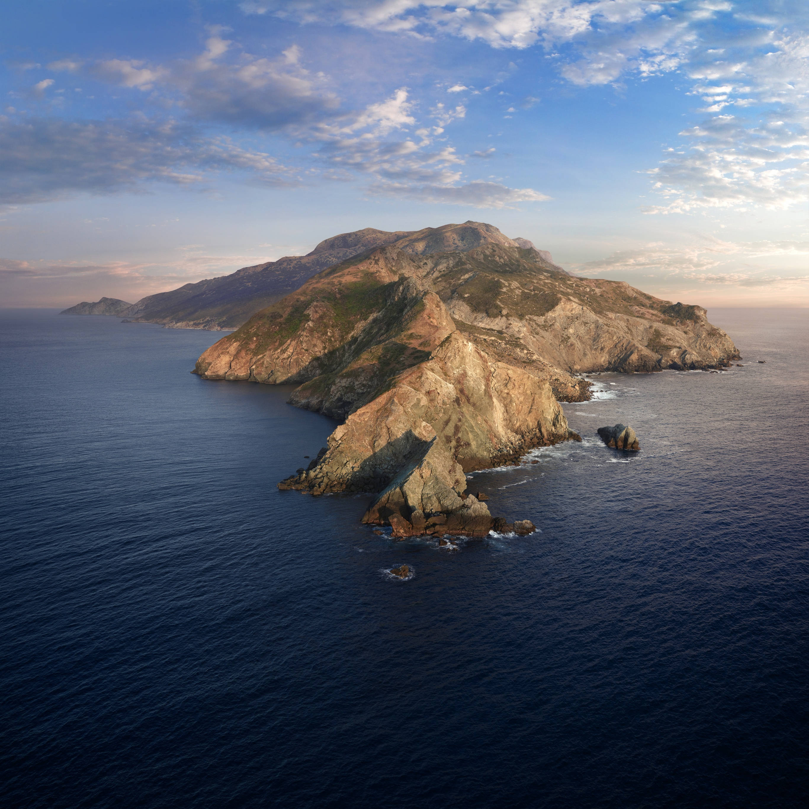 Catalina 桌布 壁紙 — 日落時分，在部分多雲的天空下，一個崎嶇多山的島嶼的鳥瞰圖，岩石懸崖伸入深藍色的海洋。