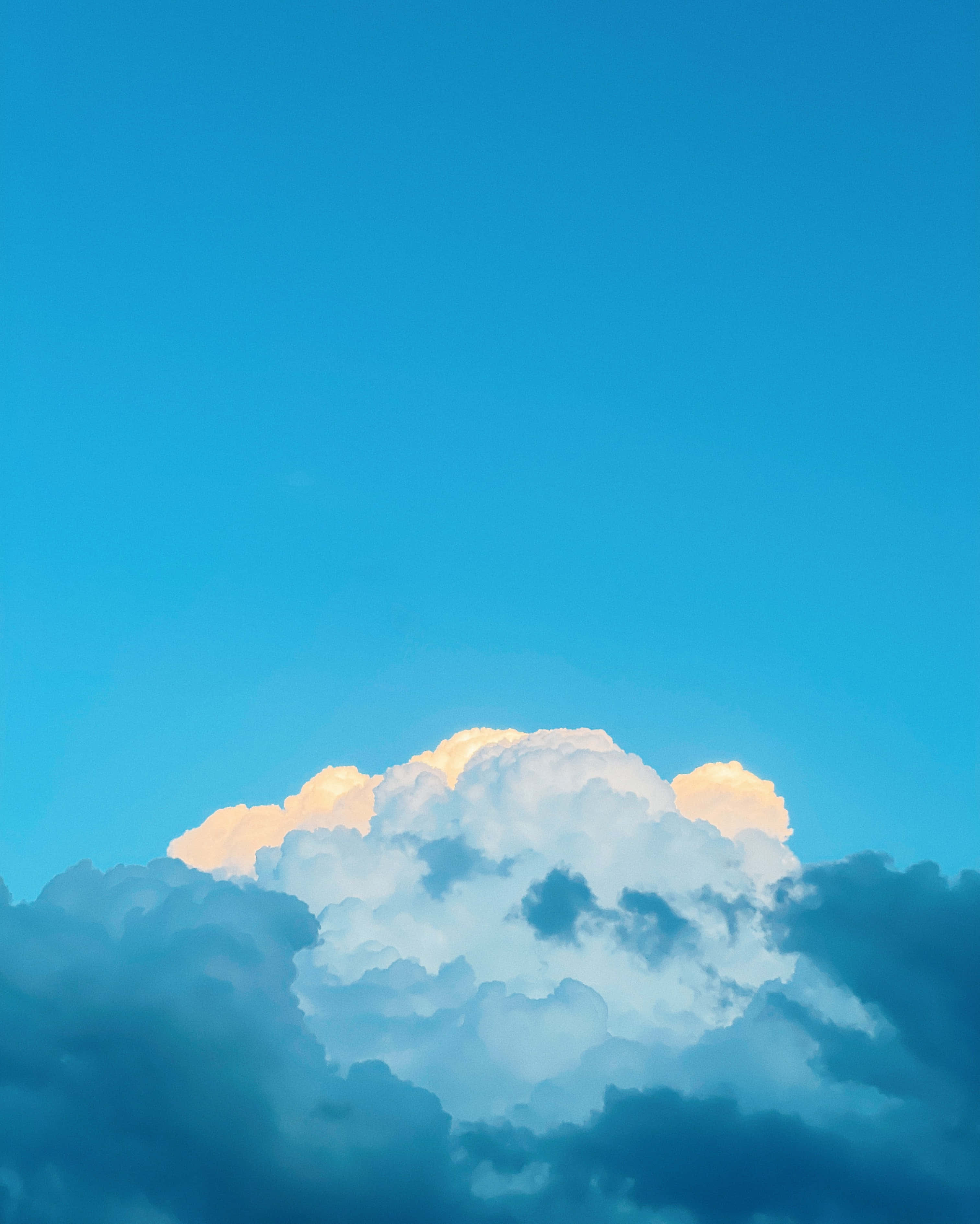 sky blue 桌布 壁紙 — 日落時分，壯麗的雲層在鮮豔的藍天中閃耀著金色的光芒。
