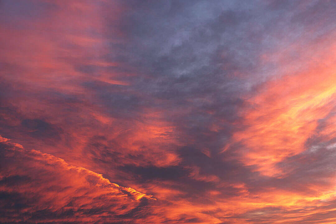 壯麗的日落天空，帶有火橙色和深紫色的雲彩。 — 4K 壁紙