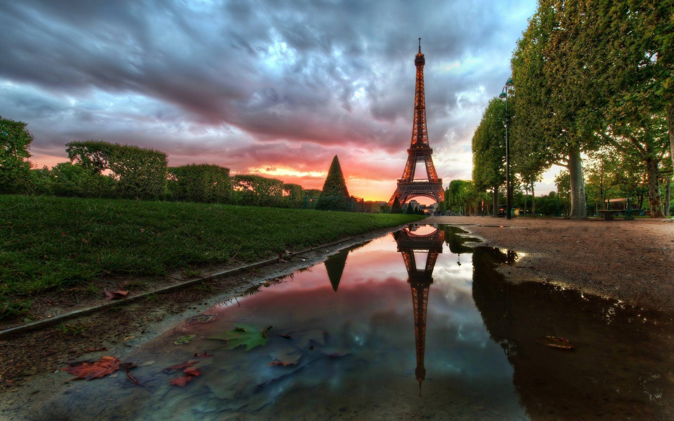 Eiffel Tower 桌布 壁紙 — 日落時分，水坑中倒映的艾菲爾鐵塔，伴隨著戲劇性的雲彩和秋葉。