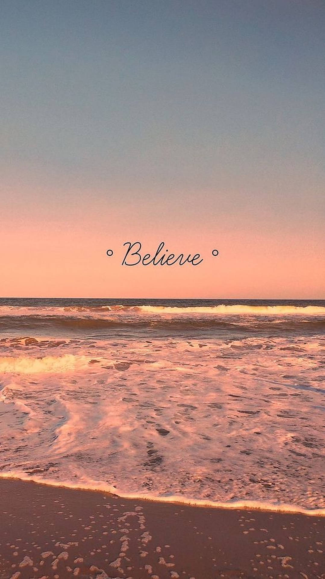 粉紅色的日落海浪湧上沙灘，天空中有「Believe」一詞。 — iPhone 美學 壁紙