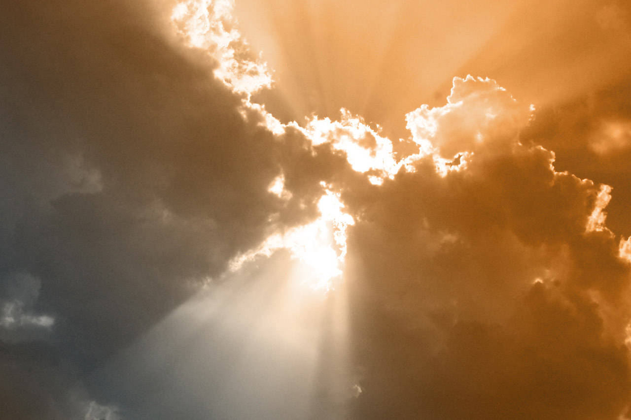 Clouds Aesthetics 桌布 壁紙 — 日落時分，金色陽光穿透戲劇性的雲層，映照在溫暖的琥珀色天空中。