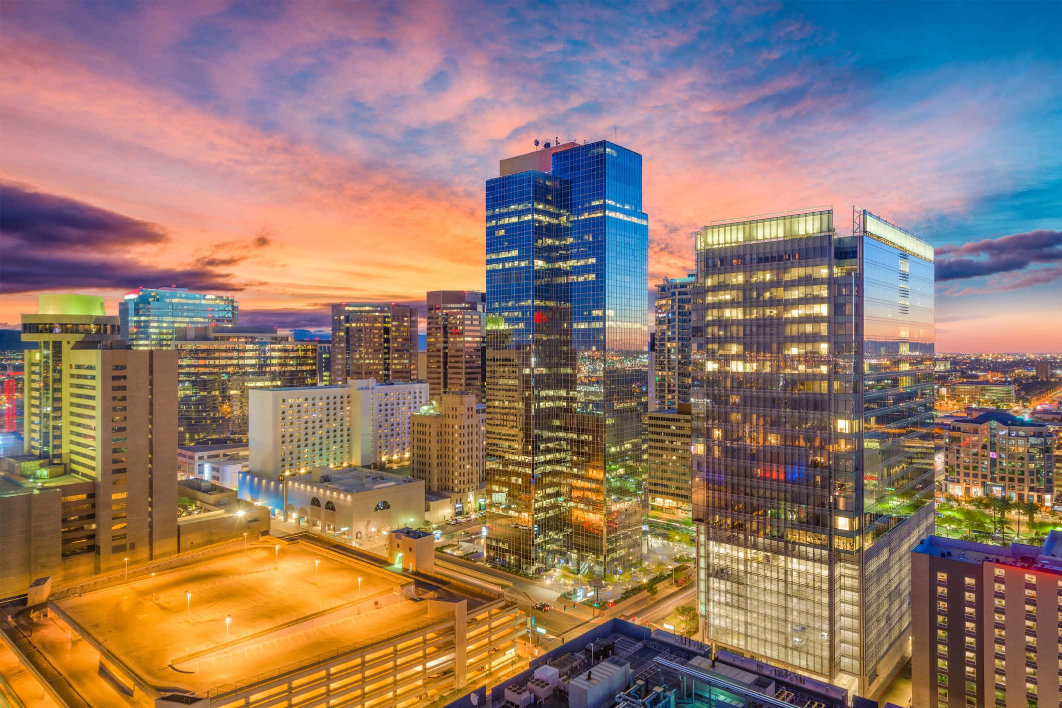 Phoenix Arizona 桌布 壁紙 — 日落時分充滿活力的城市天際線，摩天大樓在火紅的橙色和紫色天空中閃耀。
