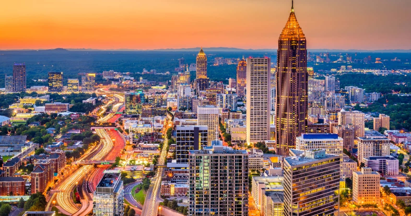 Atlanta Georgia 桌布 壁紙 — 日落時分城市天際線的鳥瞰圖，閃爍的摩天大樓和交通的光跡。