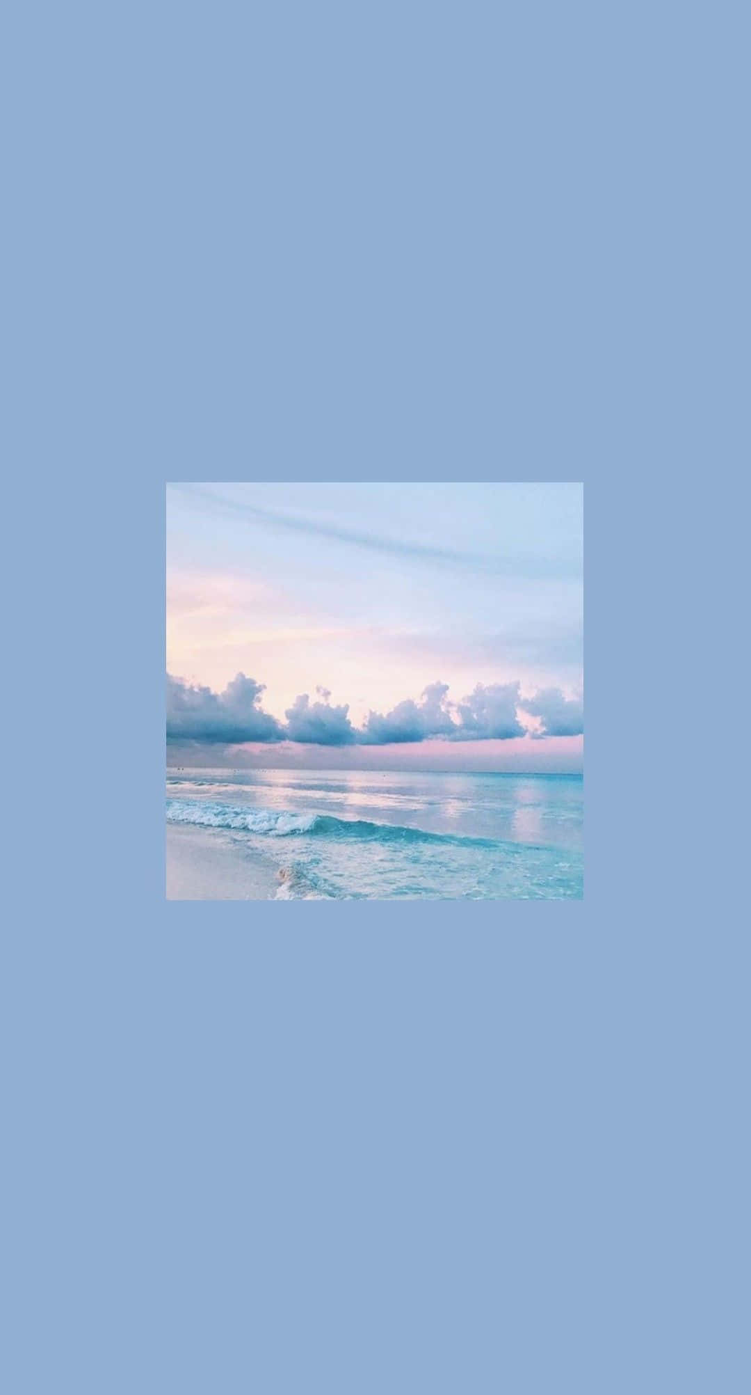 柔和美學 桌布 壁紙 — 日落時分寧靜的海灘景象，柔和粉紅與藍色天空倒映在平靜的碧綠海水上。