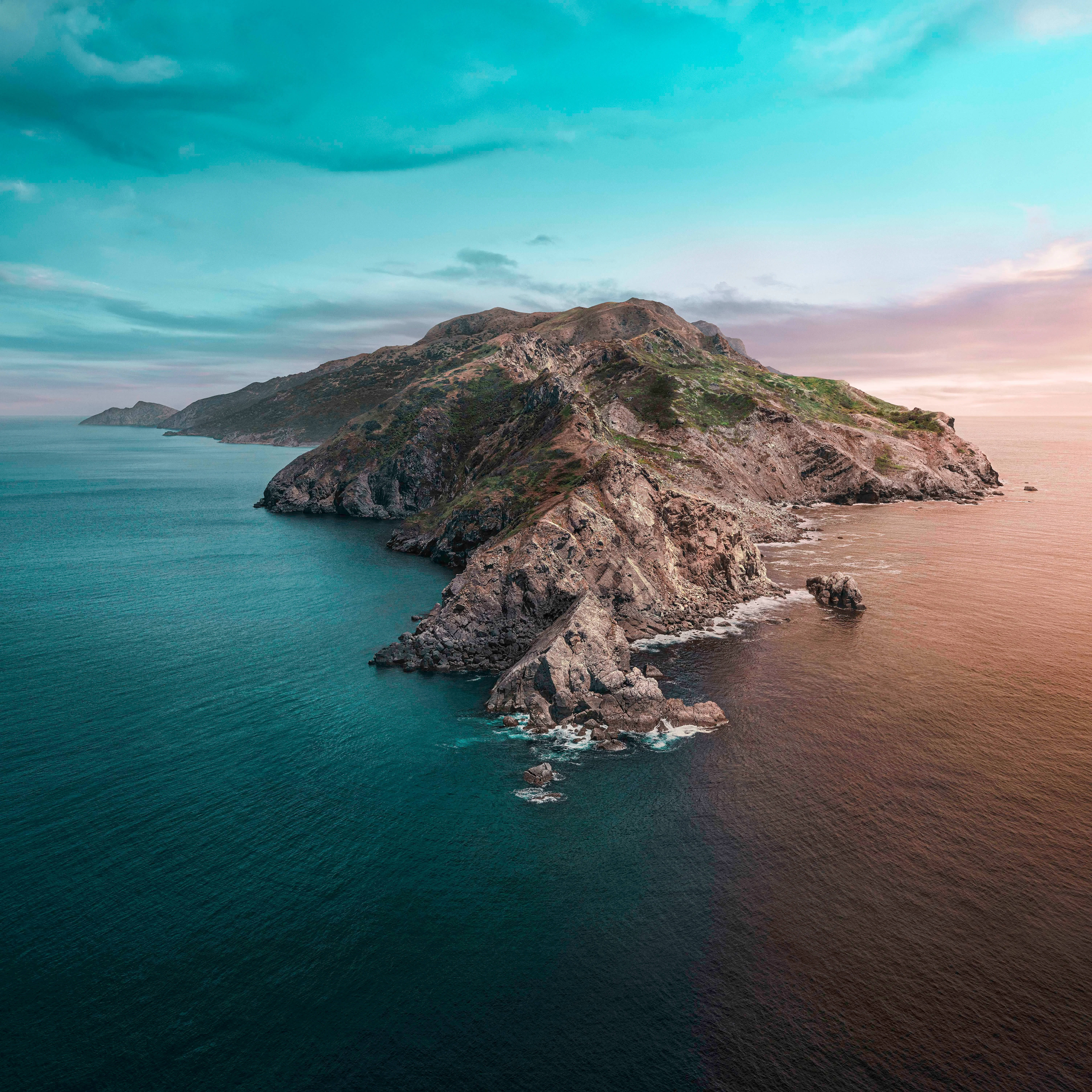 Catalina 桌布 壁紙 — 日落時分崎嶇岩石島嶼的鳥瞰圖，綠松石色和琥珀色的海水與壯觀的懸崖交匯。