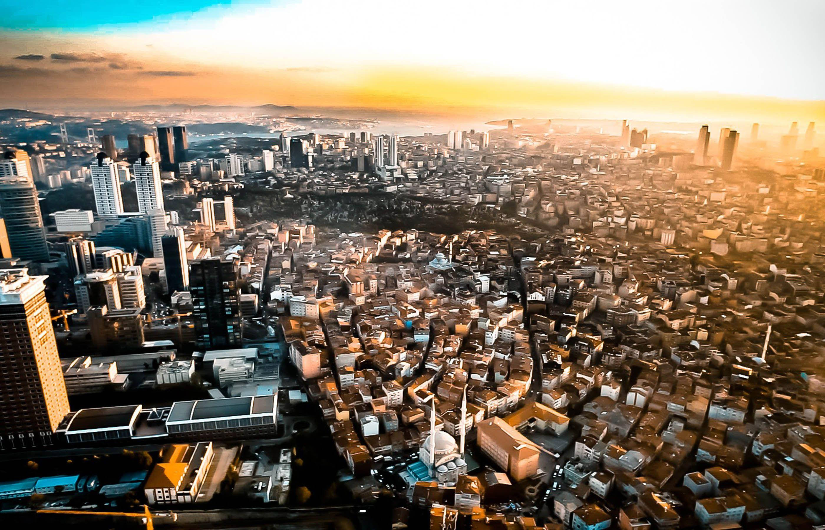Nigeria 桌布 壁紙 — 日落時分廣闊城市的鳥瞰圖，金色陽光灑滿現代摩天大樓和密集住宅區。
