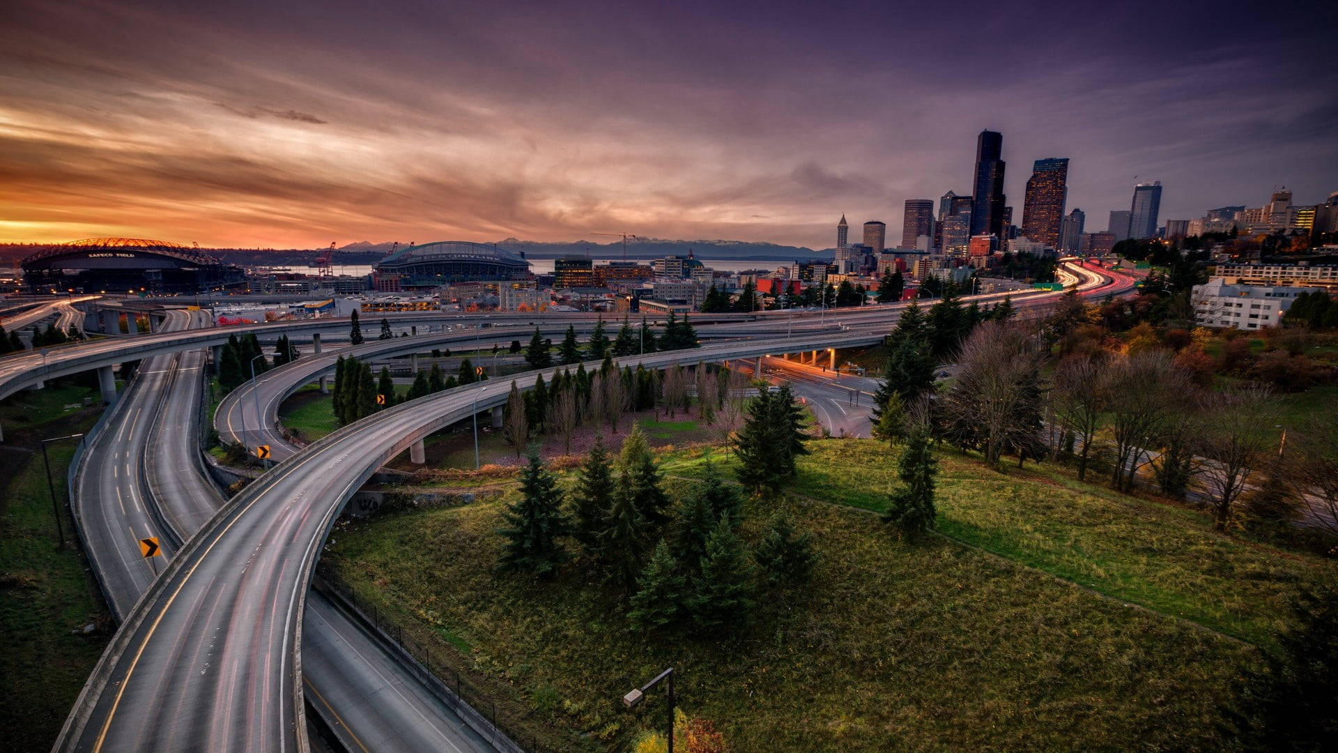 Washington 桌布 壁紙 — 日落時分廣闊的高速公路交匯處，閃爍的城市燈光與紫橙色天空。