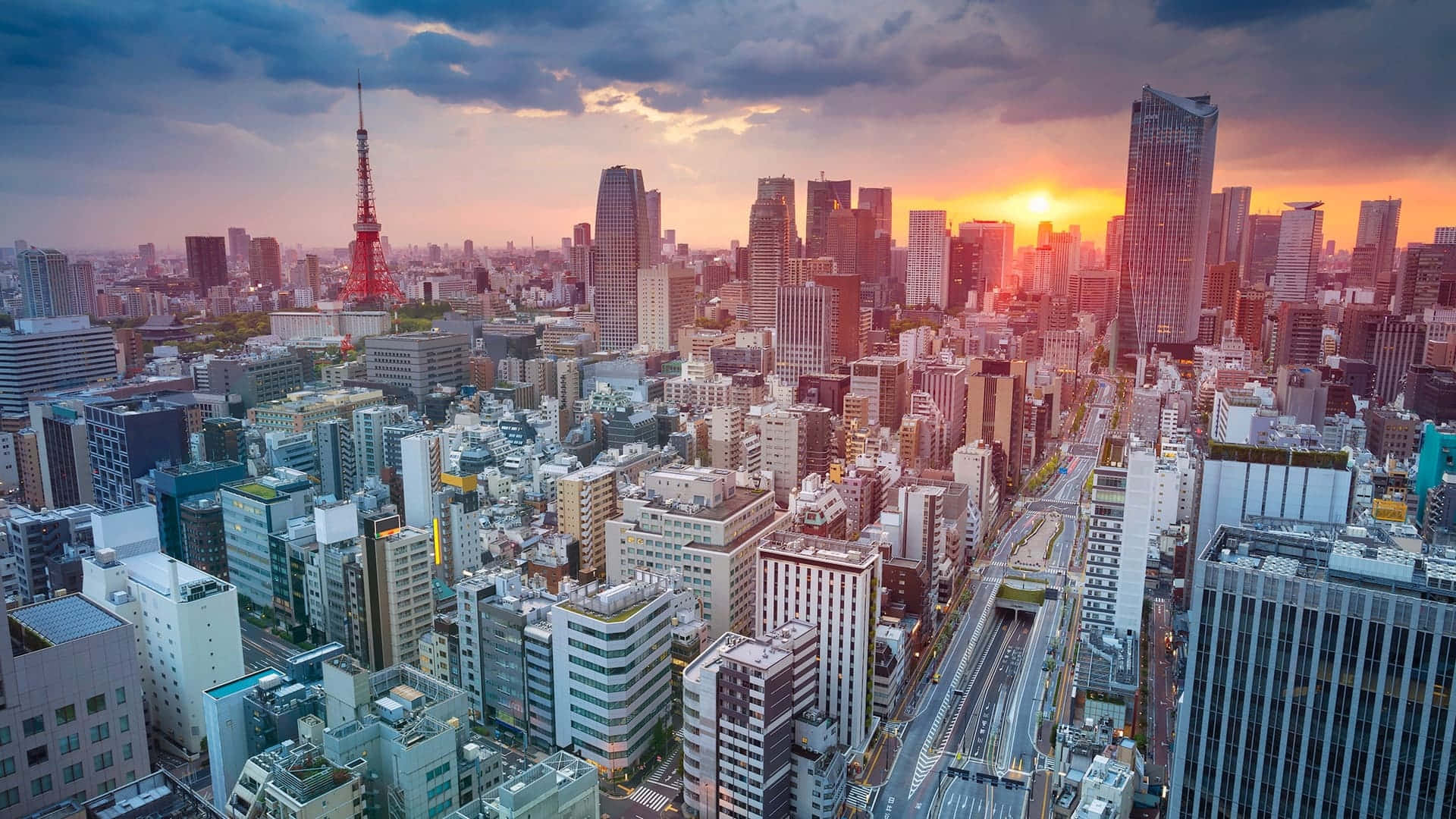 城市 桌布 壁紙 — 日落時分東京天際線的鳥瞰圖，塔橋在橙色雲層和密集的城市建築中閃耀。