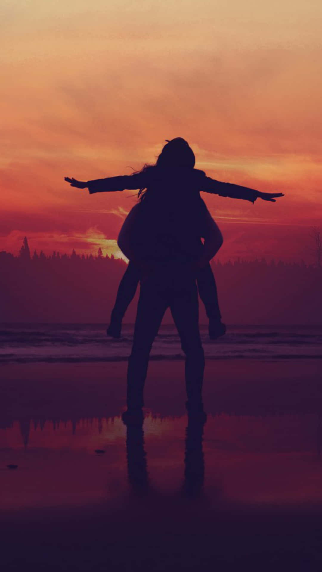 Silhouette 桌布 壁紙 — 日落時分海灘上情侶的剪影，孩子騎在肩上張開雙臂，倒映在濕沙中。