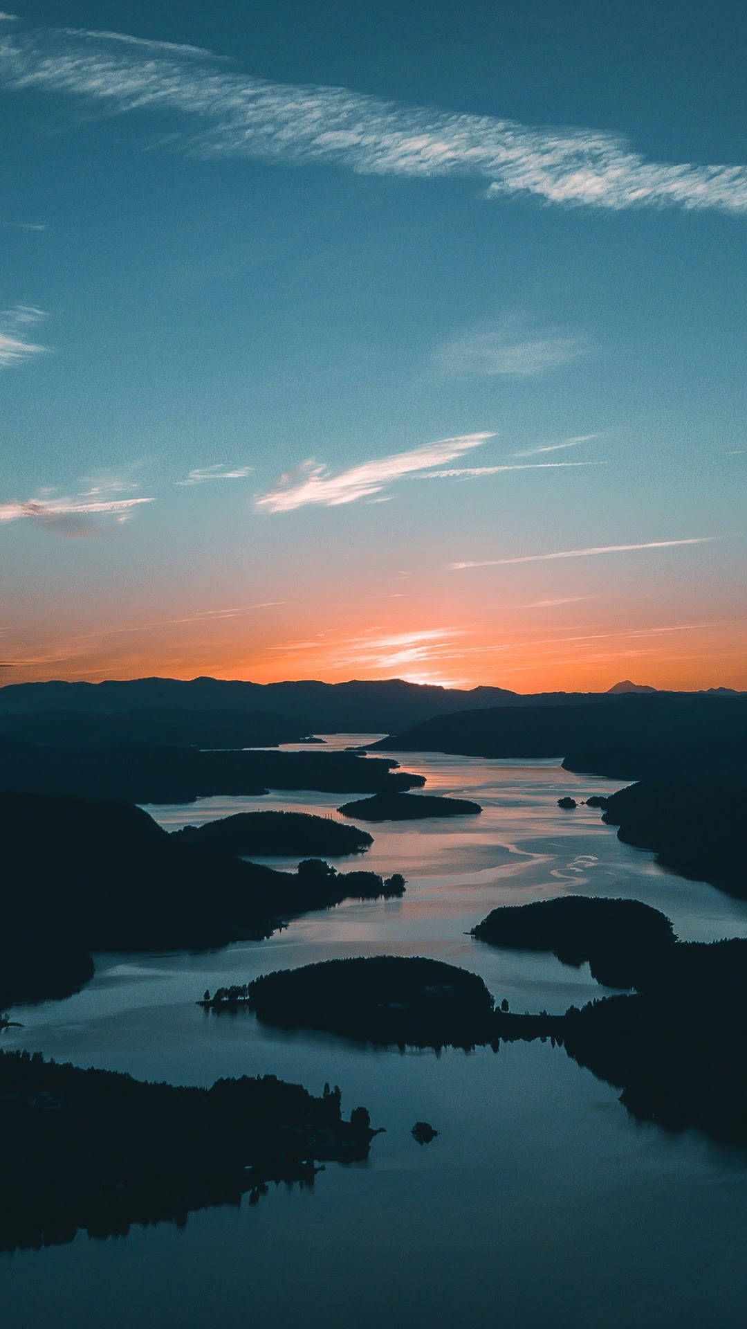 Sunset iPhone 桌布 壁紙 — 日落時分蜿蜒湖泊的鳥瞰圖，剪影島嶼和遠處山脈在漸變天空下。