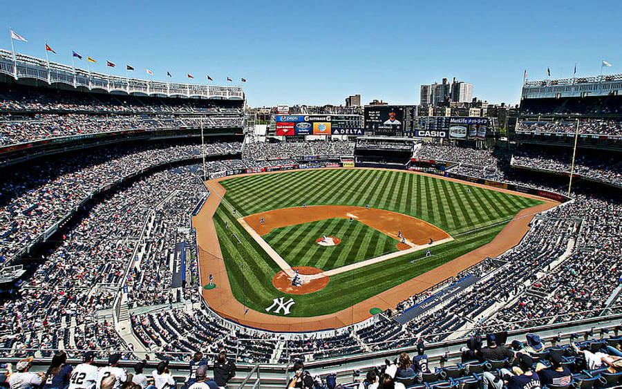 Stadium 桌布 壁紙 — 日間棒球比賽期間，明亮藍天下擠滿球迷的洋基球場鳥瞰圖。
