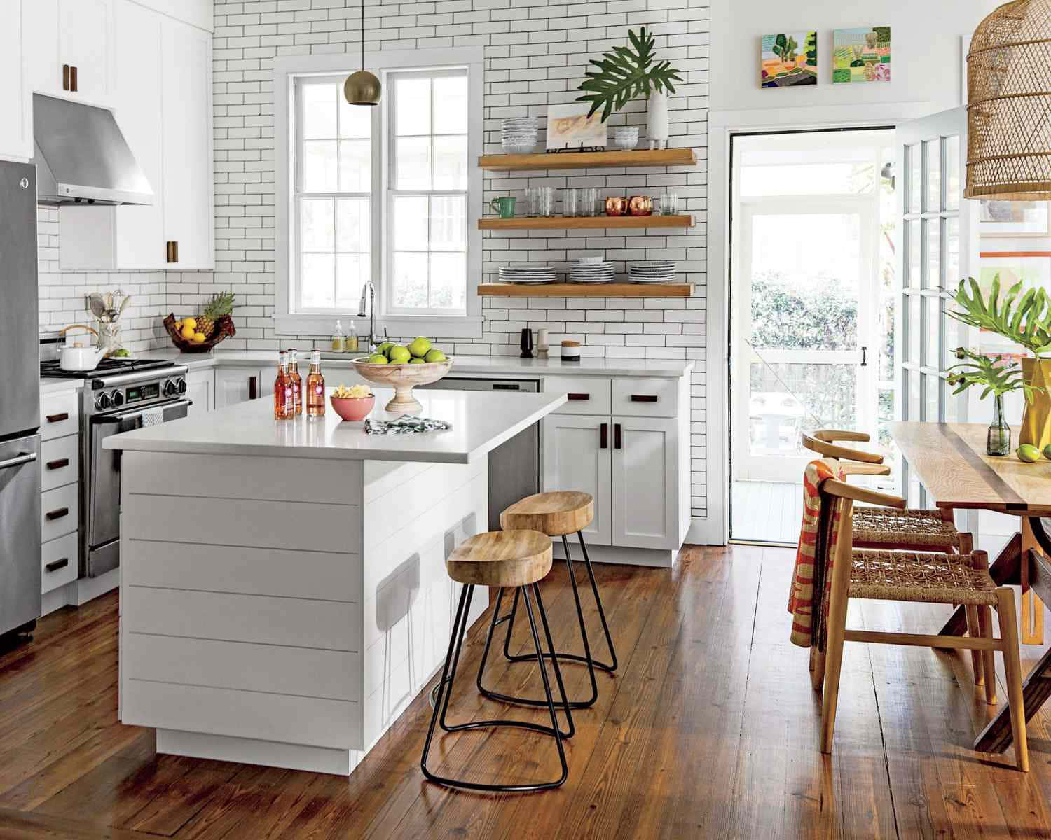 kitchen 桌布 壁紙 — 明亮現代廚房，配有白色地鐵磚、木地板和帶吧檯椅的中央島台。