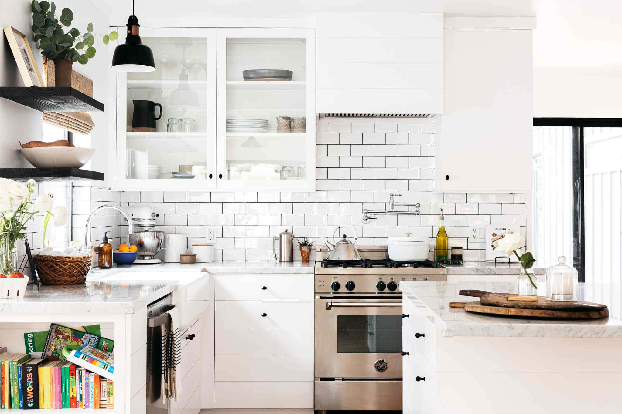 kitchen 桌布 壁紙 — 明亮現代廚房，配有白色櫥櫃、地鐵磚檯面、不鏽鋼電器，沐浴在自然光中。