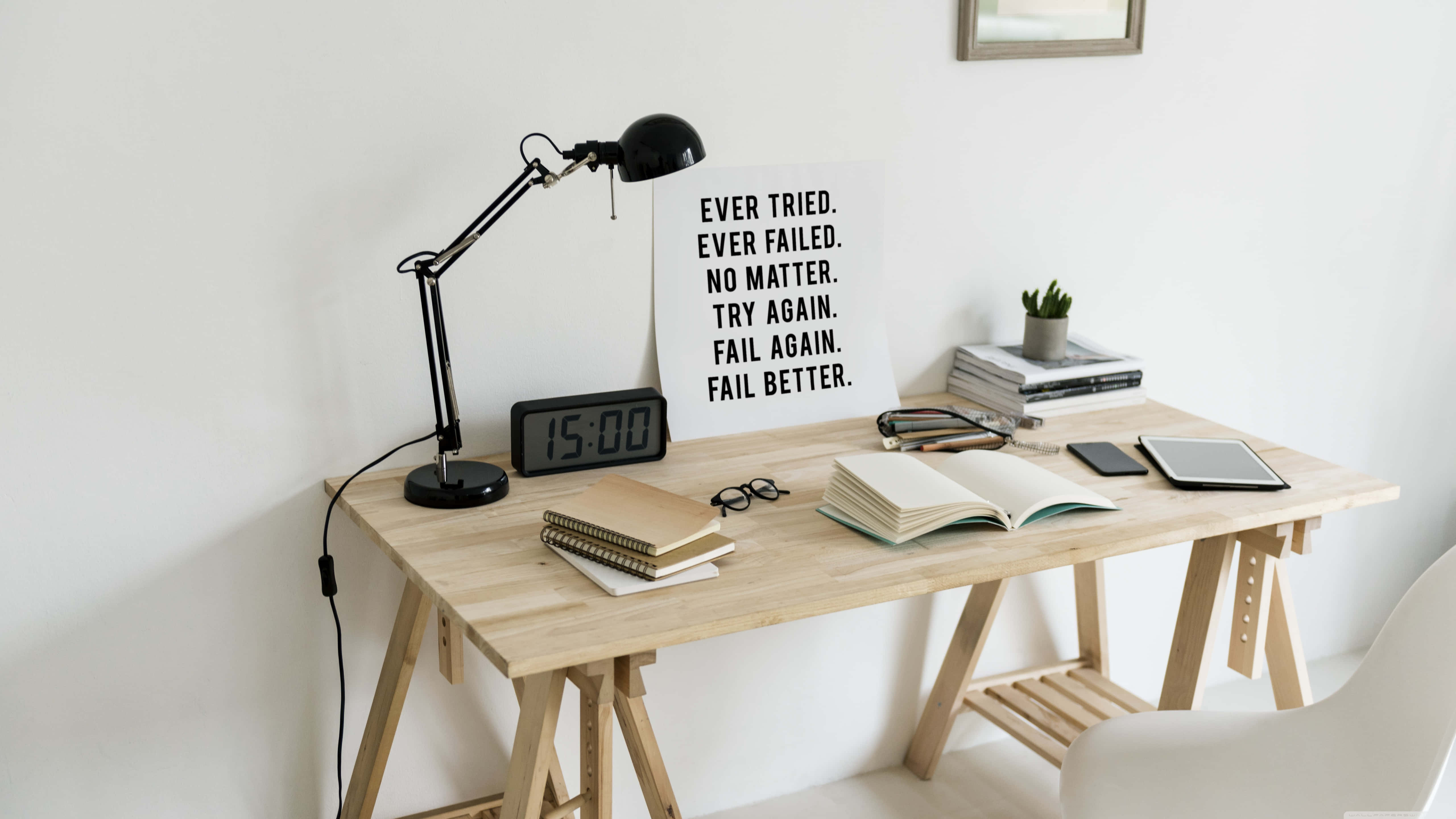 Marble Quotes 桌布 壁紙 — 明亮白色房間中的簡約木桌，配有黑色檯燈、打開的書本和勵志標語。