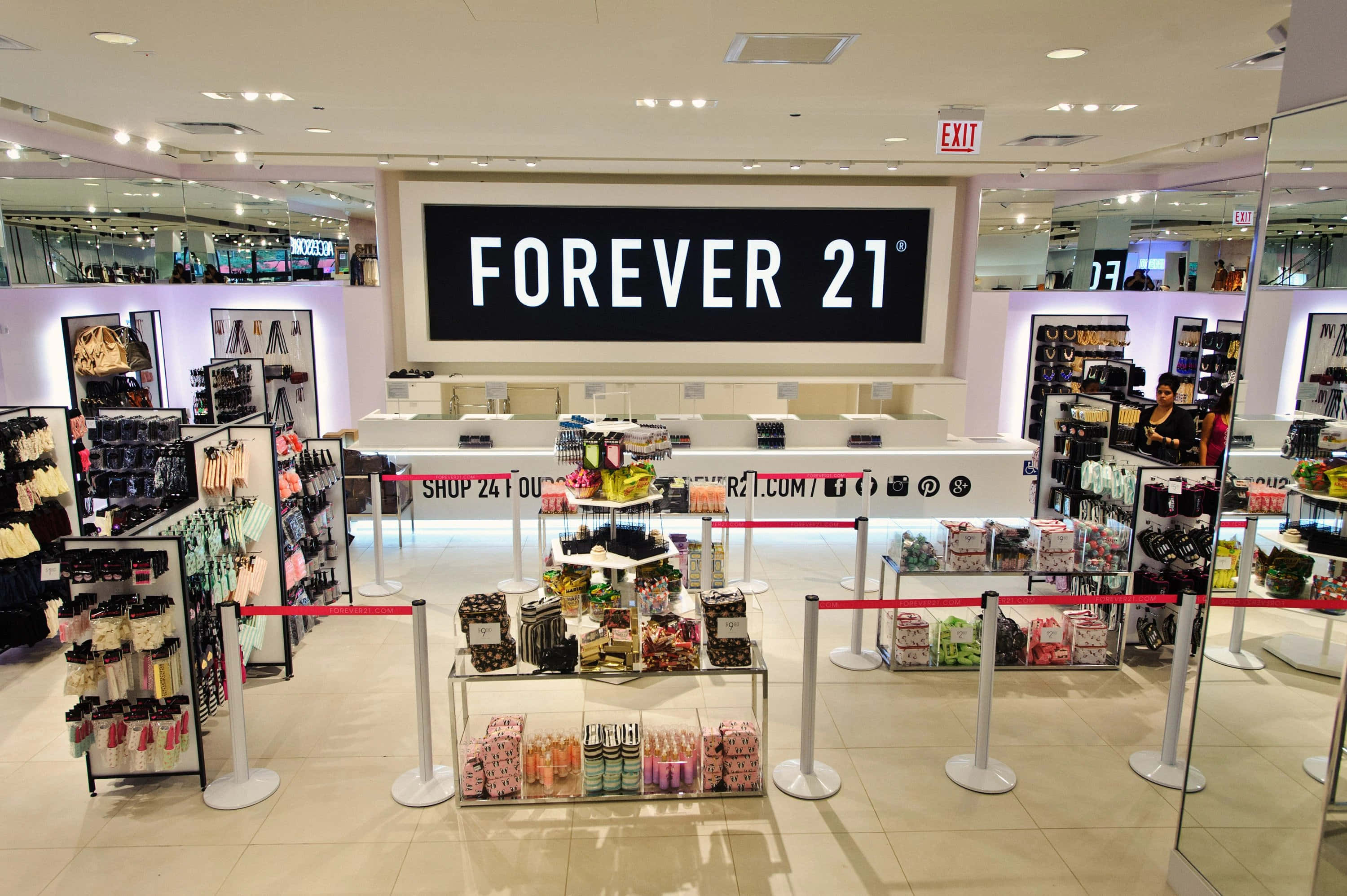 永遠21 桌布 壁紙 — 明亮的Forever 21店內，設有商品展示和紅色欄柱，上方有大型品牌標誌。