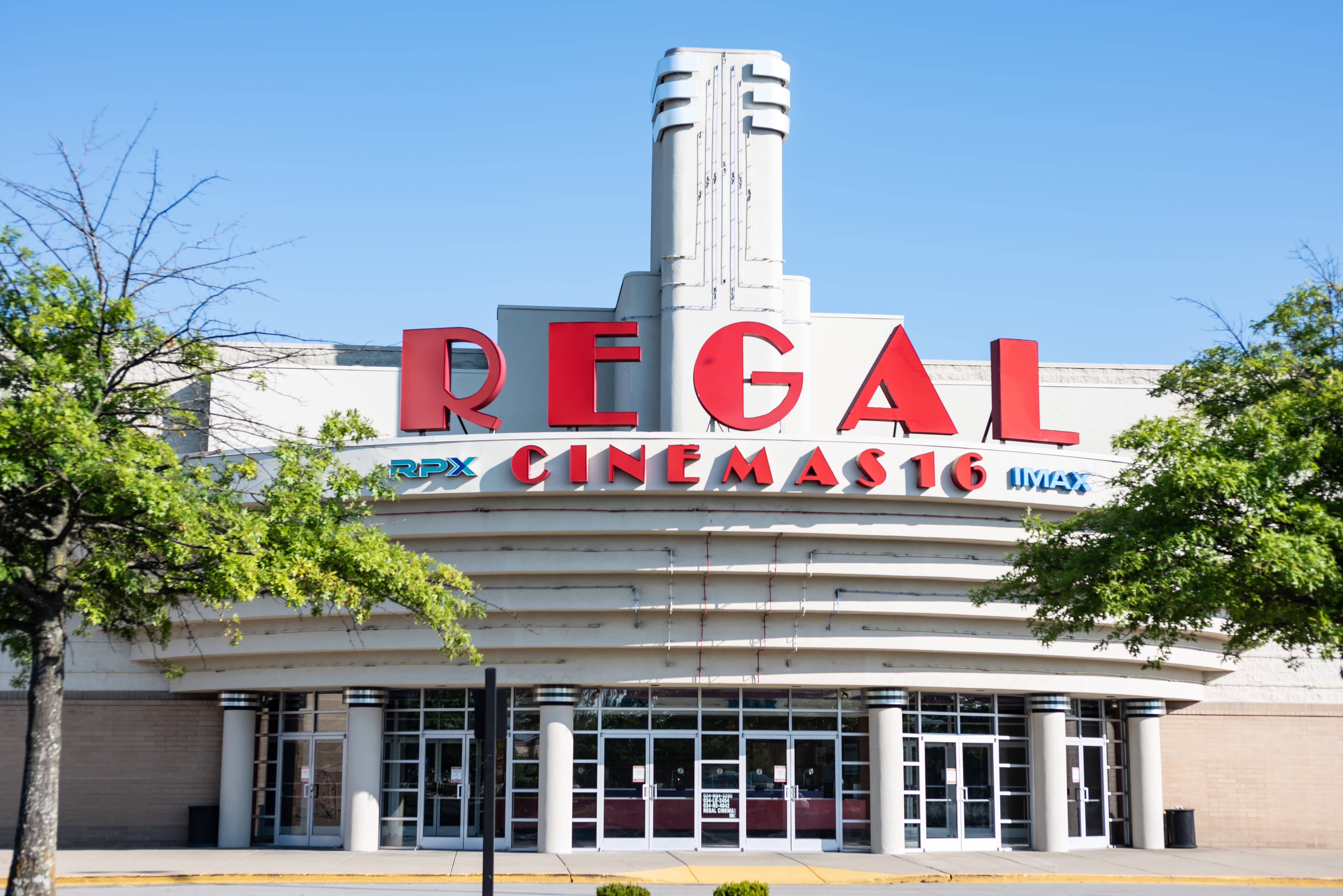 Regal 桌布 壁紙 — 明亮的Regal Cinemas 16影院，紅色招牌和綠樹映襯在清澈的藍天下。