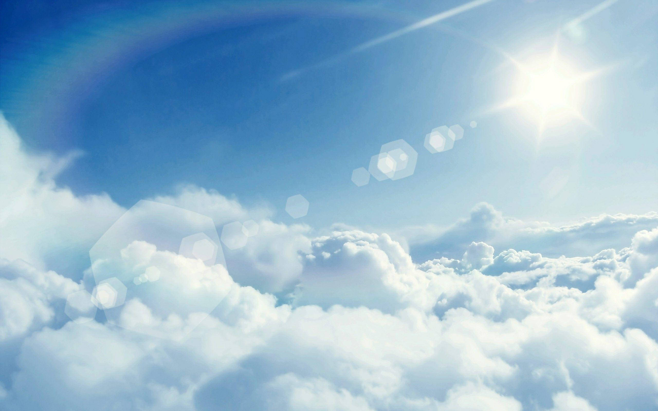 太陽 桌布 壁紙 — 明亮的太陽照耀在蓬鬆的白雲之上，湛藍的天空帶有鏡頭光暈效果。