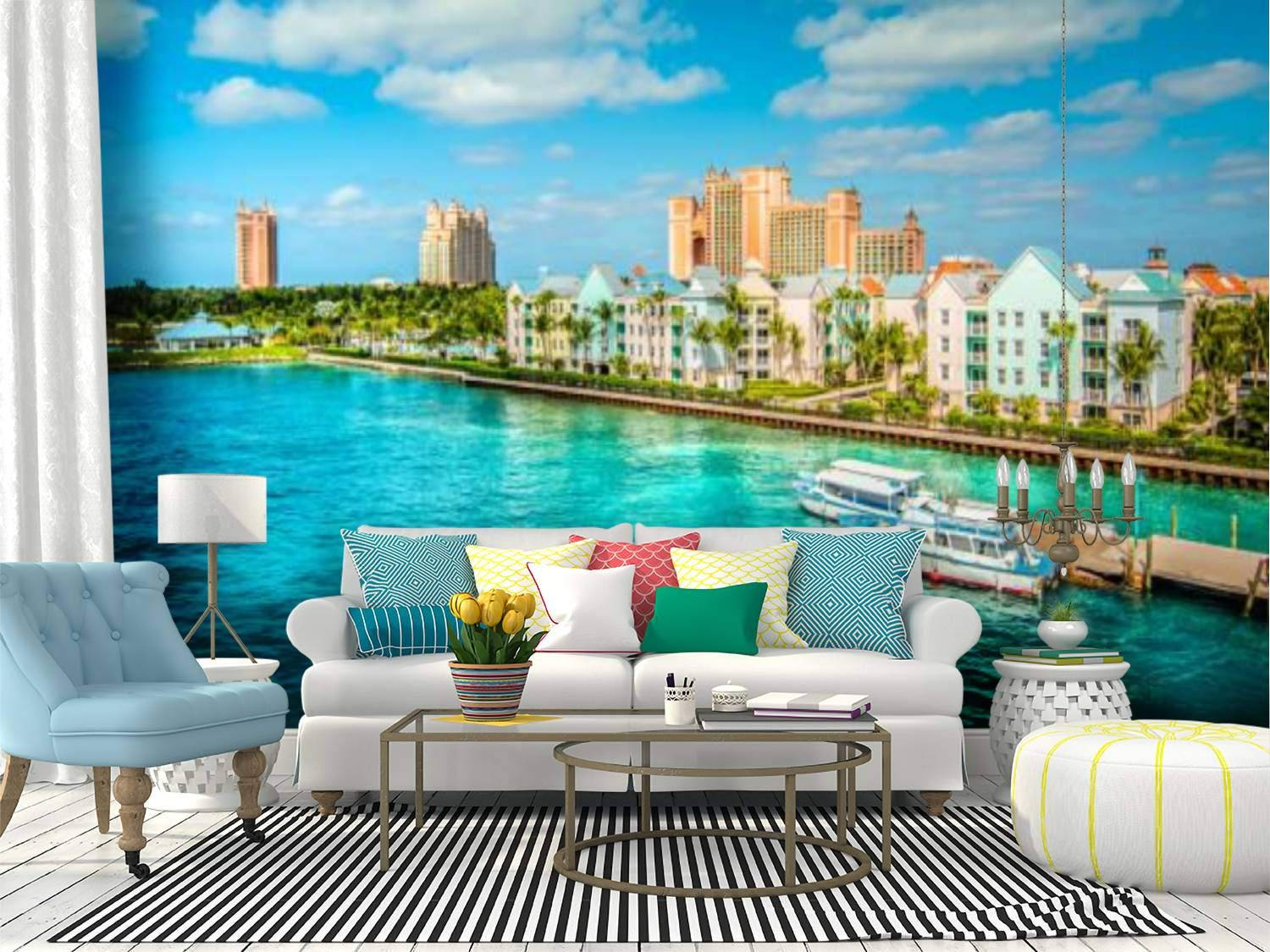 Nassau Bahamas 桌布 壁紙 — 明亮的客廳設有一幅大型熱帶港口的壁紙壁畫，描繪了在陽光明媚的藍天下，碧綠的海水和粉彩建築。