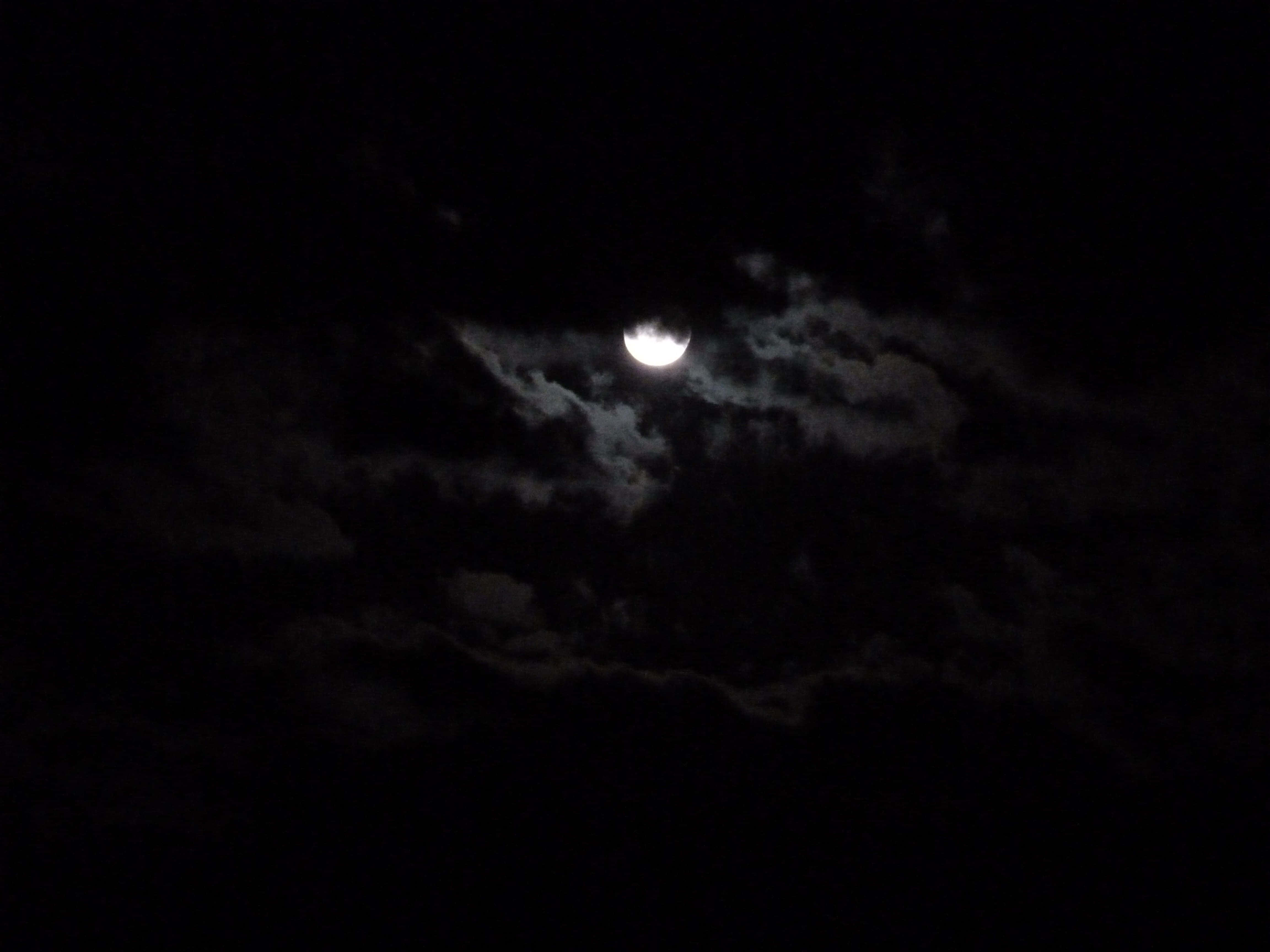 Moonlight 桌布 壁紙 — 明亮的彎月透過縷縷雲層，在深邃的黑色夜空中閃耀。