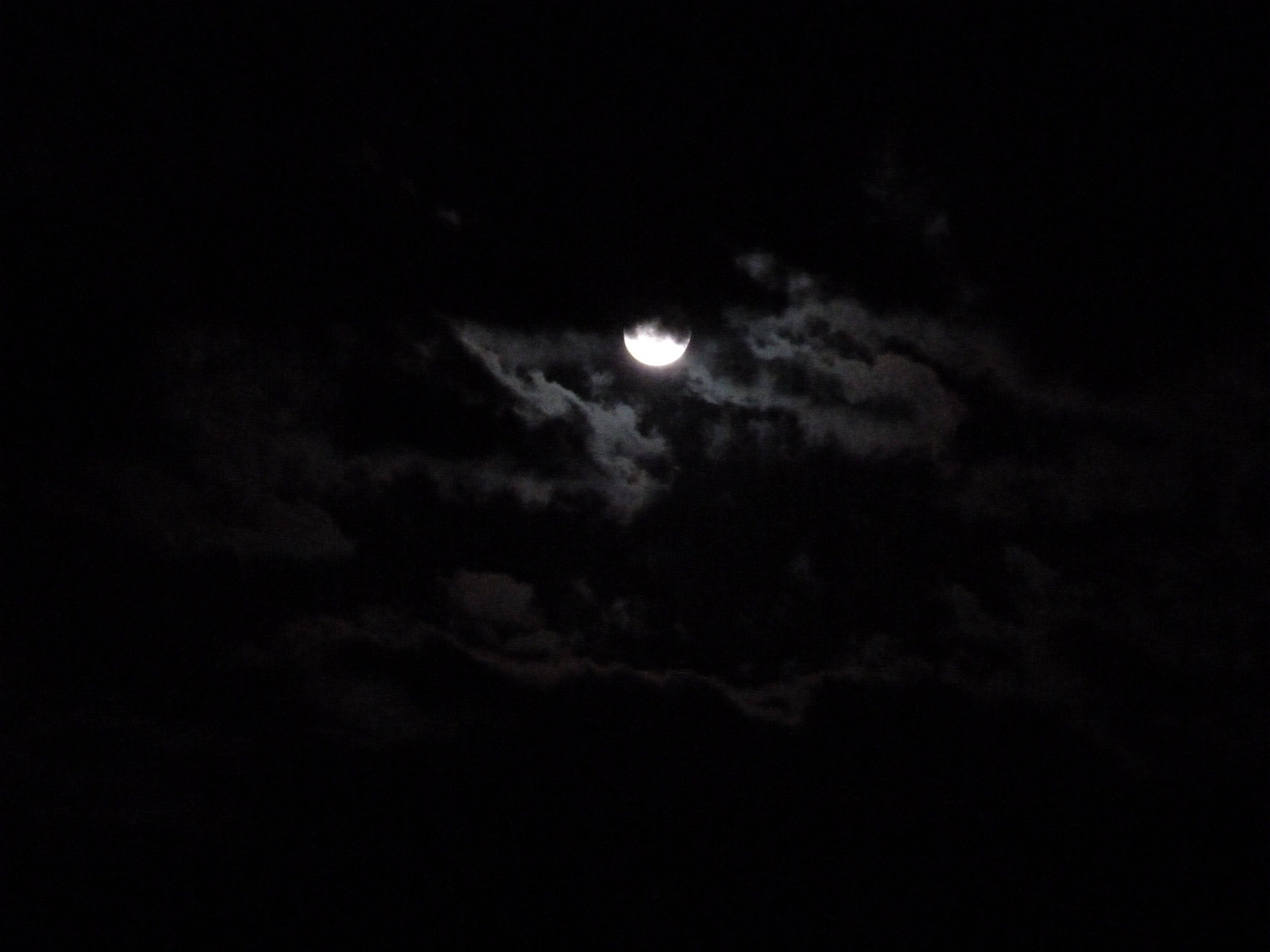 黑夜 桌布 壁紙 — 明亮的彎月透過縷縷雲層在深黑色的夜空中閃耀。