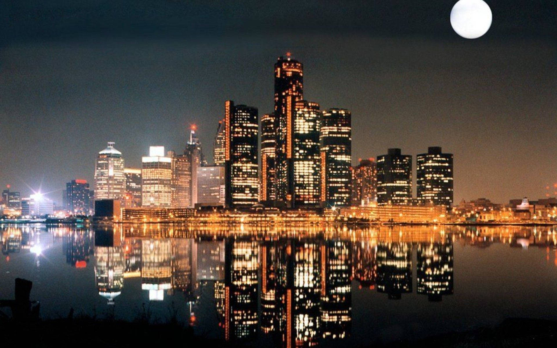Ontario 桌布 壁紙 — 明亮的滿月下，充滿活力的城市天際線倒映在平靜的水面上。