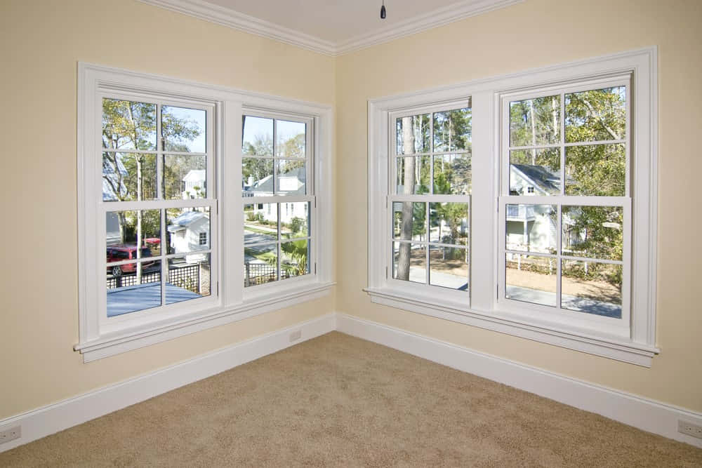 window 桌布 壁紙 — 明亮的空房間，米色牆壁和地毯，白色窗框，窗外是綠樹成蔭的郊區街道。