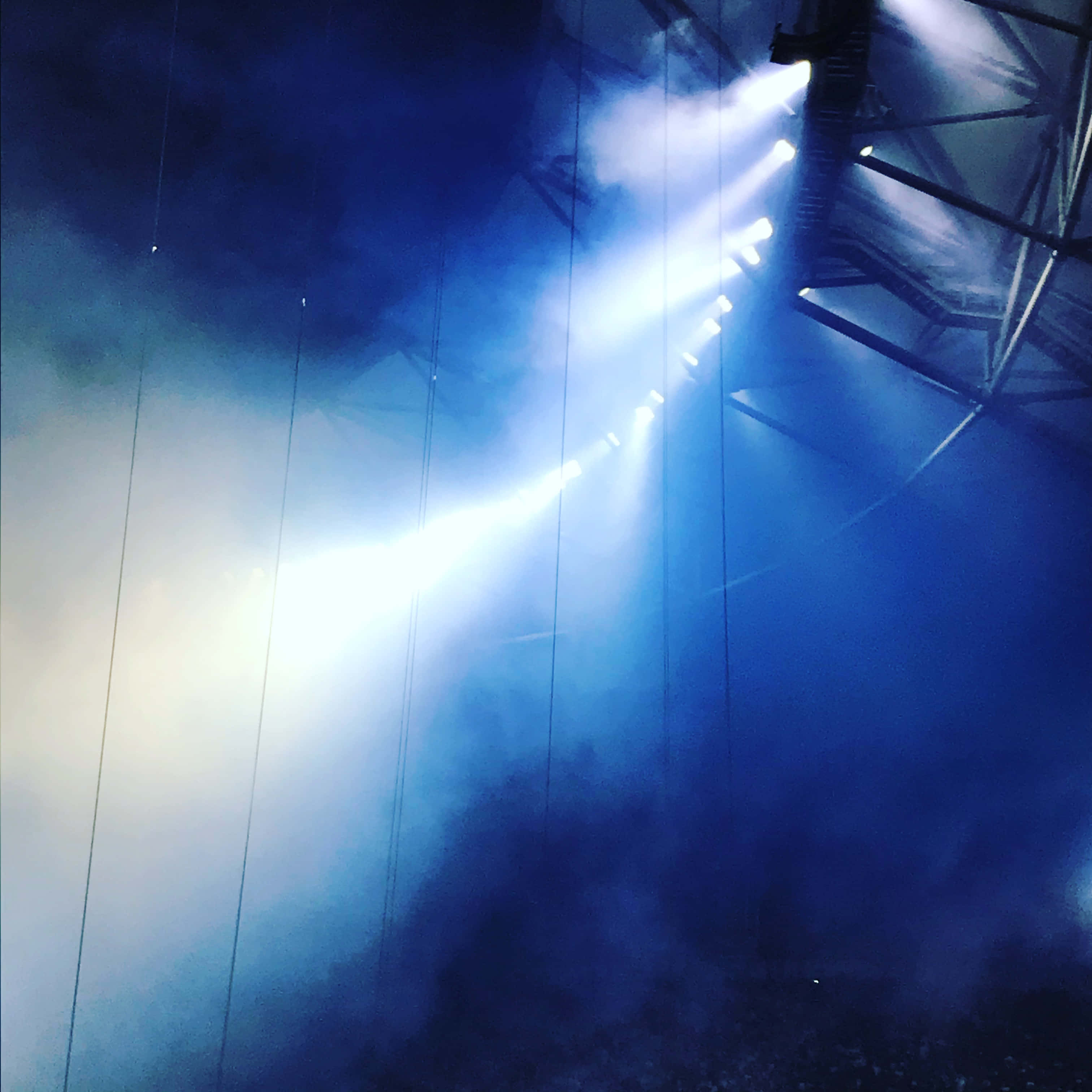 Stage Light 桌布 壁紙 — 明亮的舞台燈光穿透音樂會場地的藍色煙霧和懸掛的電纜。