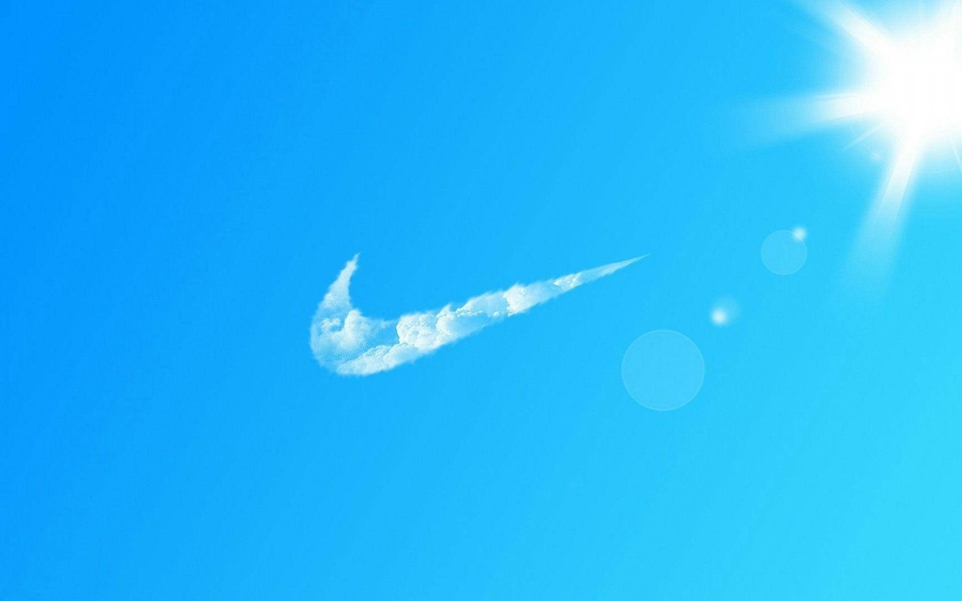 酷炫耐吉 桌布 壁紙 — 明亮的藍天中，一朵白色雲朵形狀像Nike的勾號，右上角有耀眼的太陽。