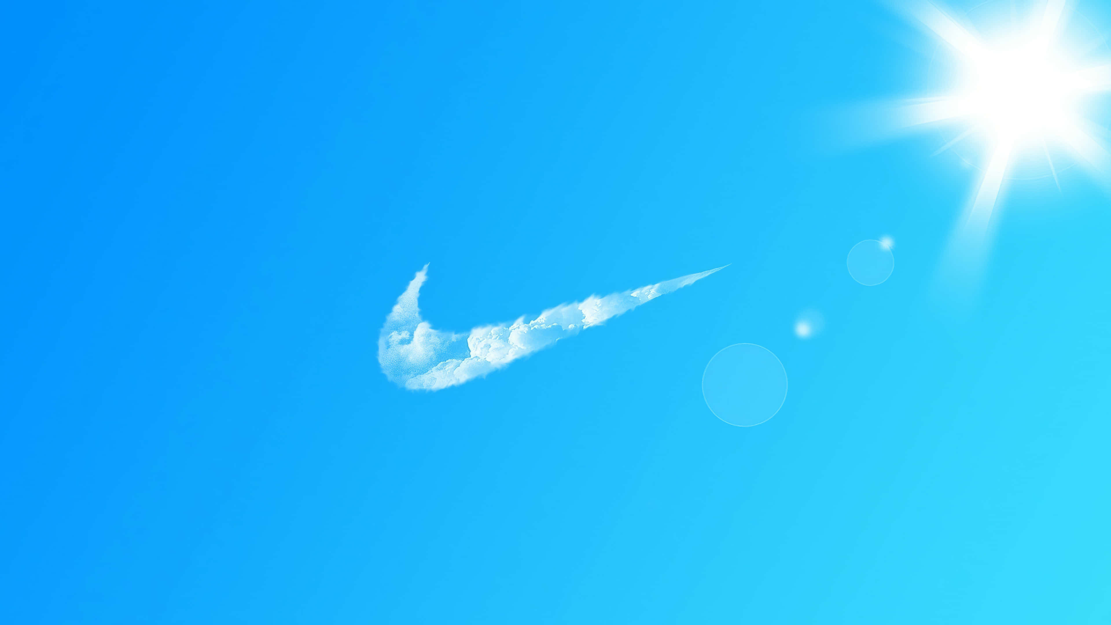 桌布 壁紙 — 明亮的藍天中有一朵形狀像Nike swoosh的白雲，角落裡有耀眼的太陽。