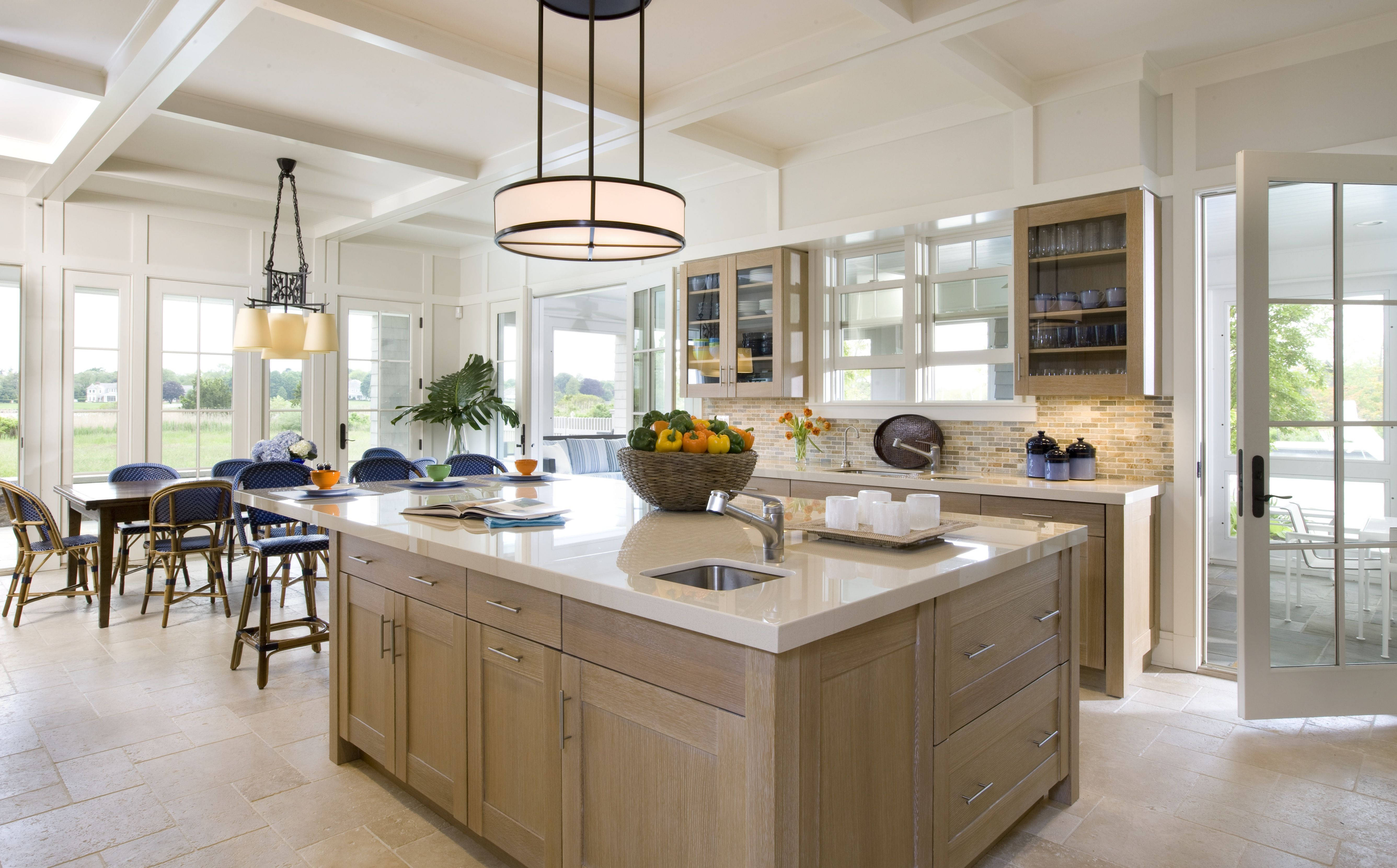 Kitchen Design 桌布 壁紙 — 明亮通風的廚房，配有淺色木櫃、白色檯面，以及可俯瞰綠色草坪的大窗戶。