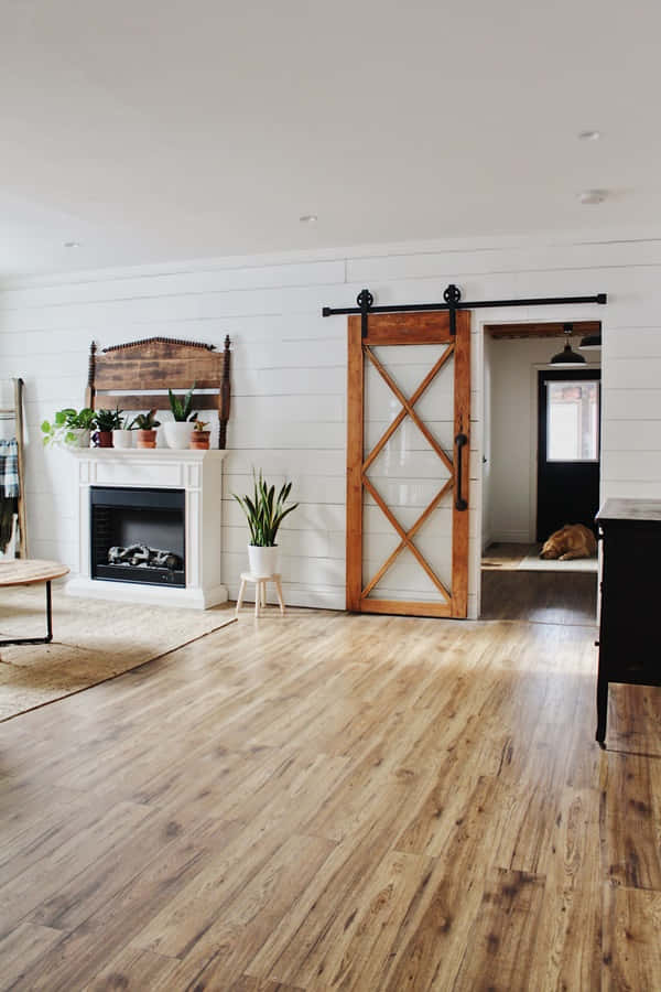 Shiplap 桌布 壁紙 — 明亮通風的農舍客廳，配有白色護牆板牆壁、木製穀倉門和硬木地板。