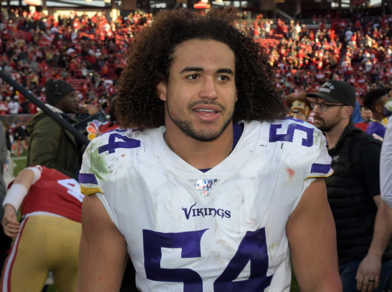 Eric Kendricks 桌布 壁紙 — 明尼蘇達維京人隊美式足球員的近照，頭髮捲曲，身穿白色和紫色54號球衣，在擠滿觀眾的球場上。