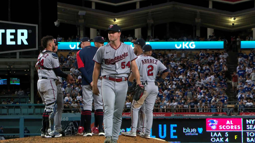 twins 桌布 壁紙 — 明尼蘇達雙城棒球選手穿著灰色球衣，在夜間球場燈光下從投手丘走下來，背景是滿座的觀眾。