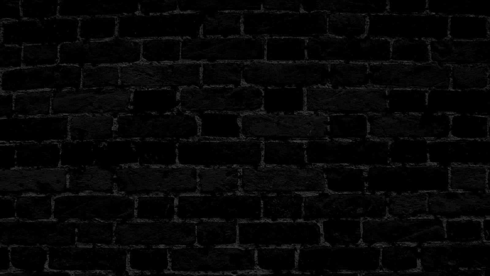 Black Brick 桌布 壁紙 — 昏暗燈光下，帶有細微灰色砂漿線條的深色紋理磚牆特寫。