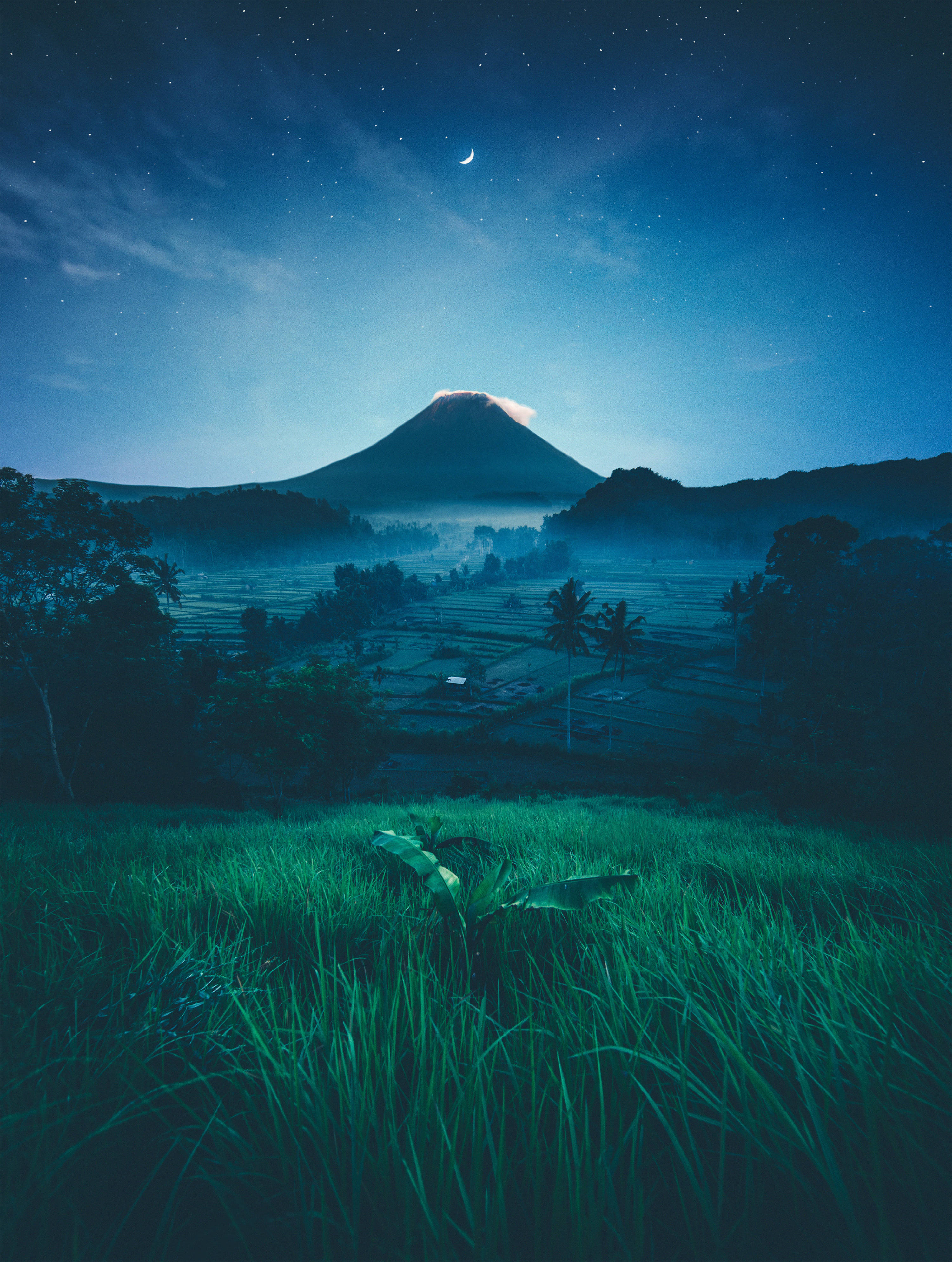 美少女戰士 桌布 壁紙 — 星空下，霧氣籠罩的火山山脈與新月在梯田之上的寧靜夜景。