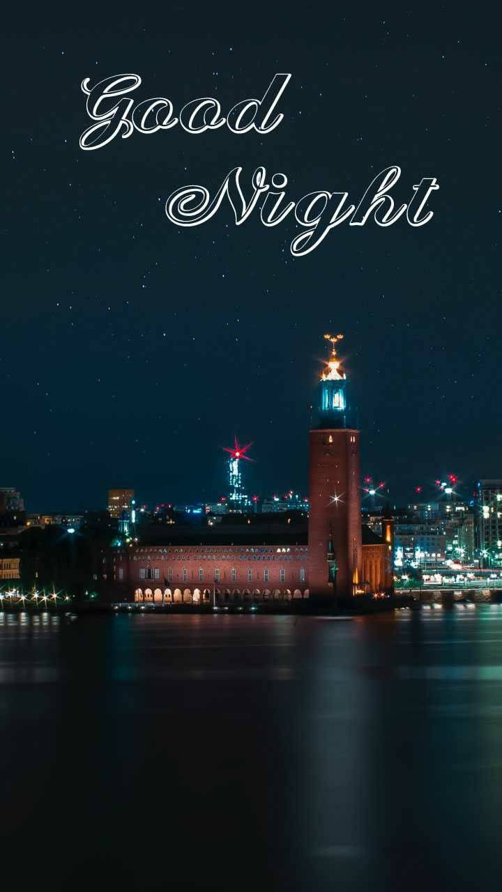 Good Night 桌布 壁紙 — 星空下的夜景城市景觀，寧靜水面倒映著發光的塔樓，上方寫著「晚安」。