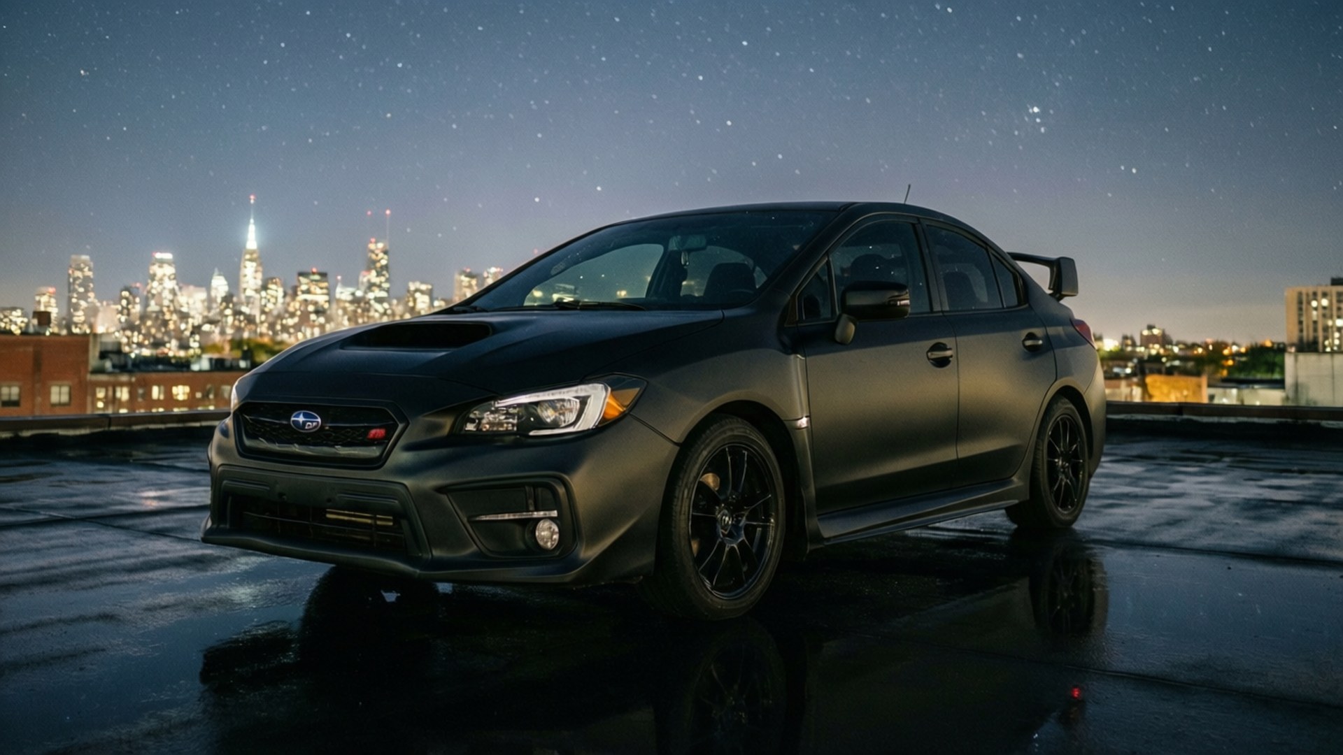 星空下的屋頂 壁紙 — 一輛霧面黑色的Subaru WRX STI停在濕漉漉的屋頂上，背景是星空下的璀璨城市天際線。