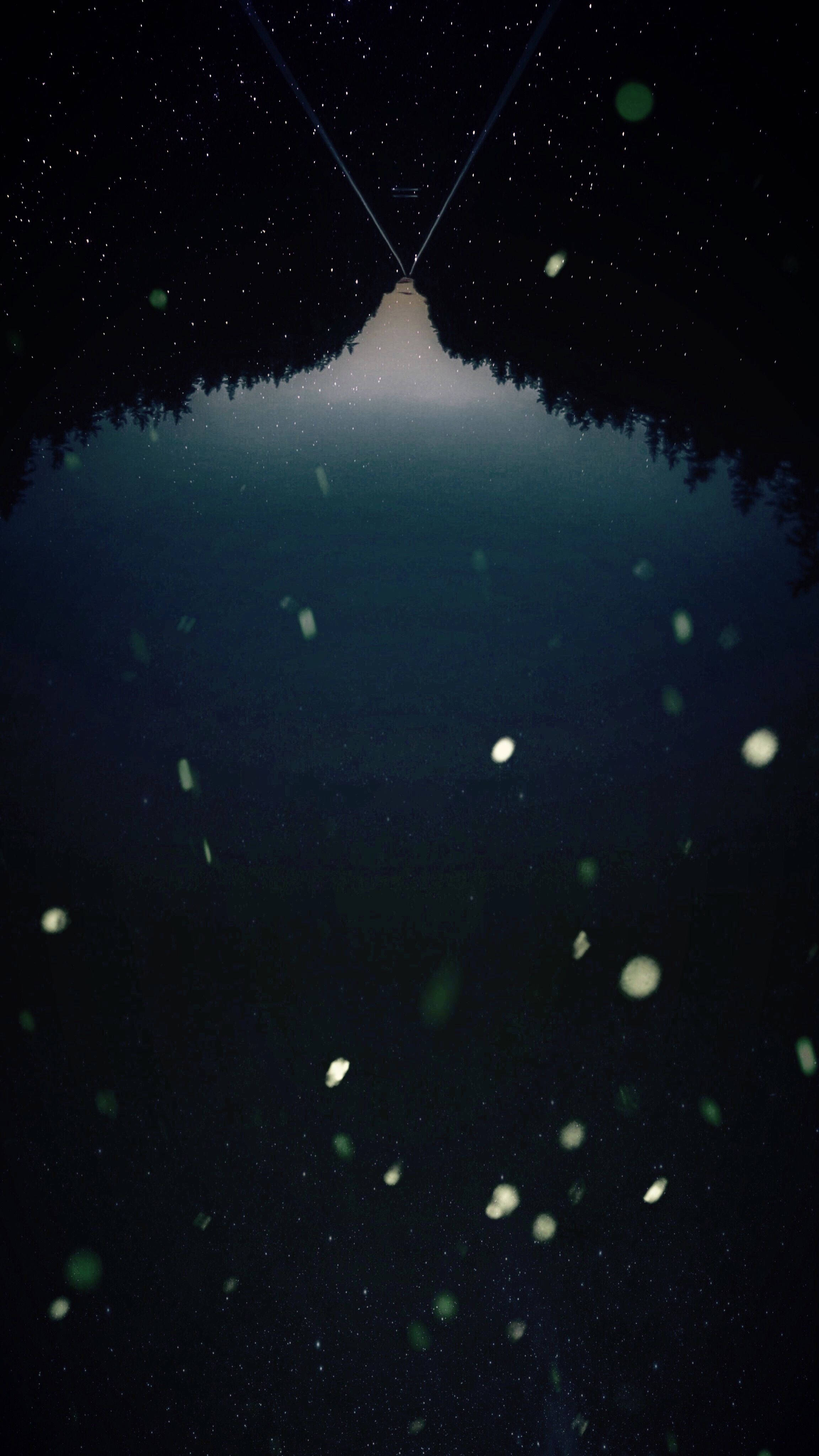Screen 桌布 壁紙 — 星空倒映在平靜的湖面上，前景有發光的粒子漂浮。