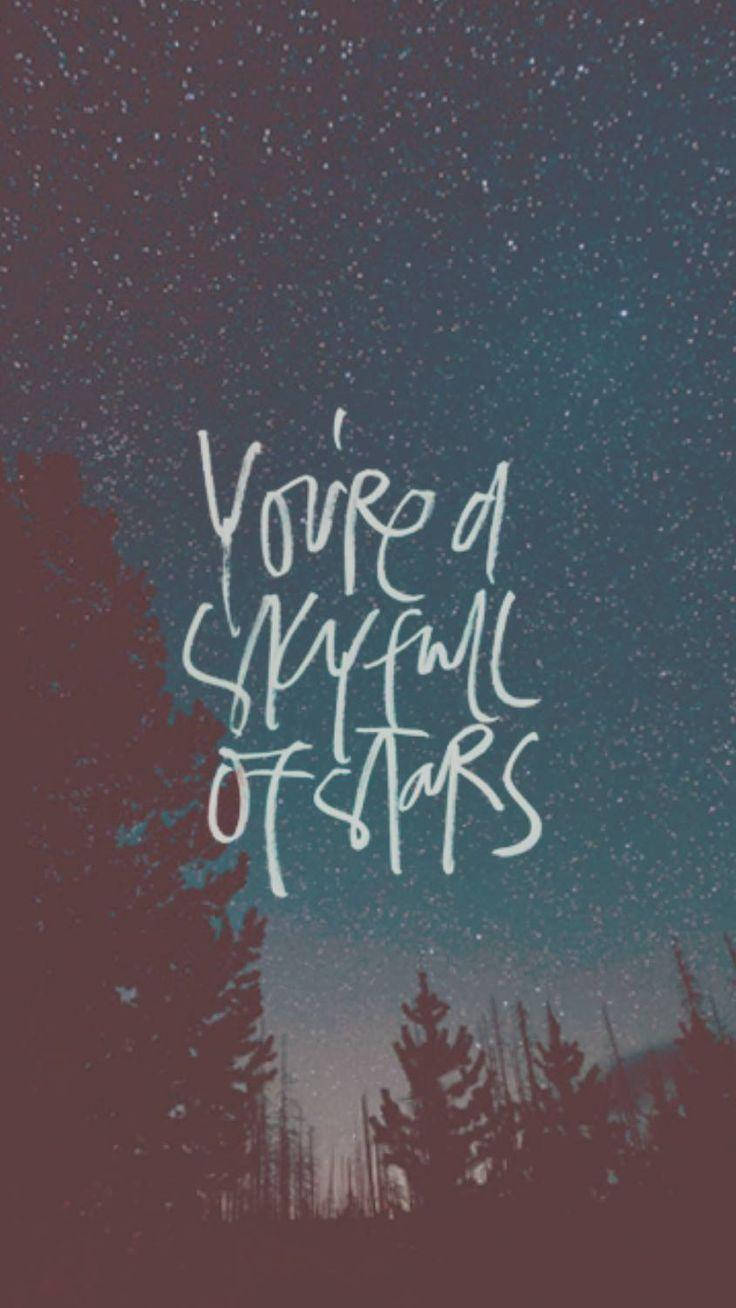 酷玩樂團 桌布 壁紙 — 星空夜景，松樹剪影上方有手寫文字 'You're a sky full of stars'。
