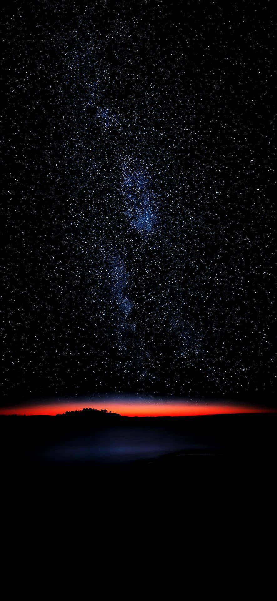 桌布 壁紙 — 星空夜空，暗色陸地剪影上方有發光的紅色地平線。