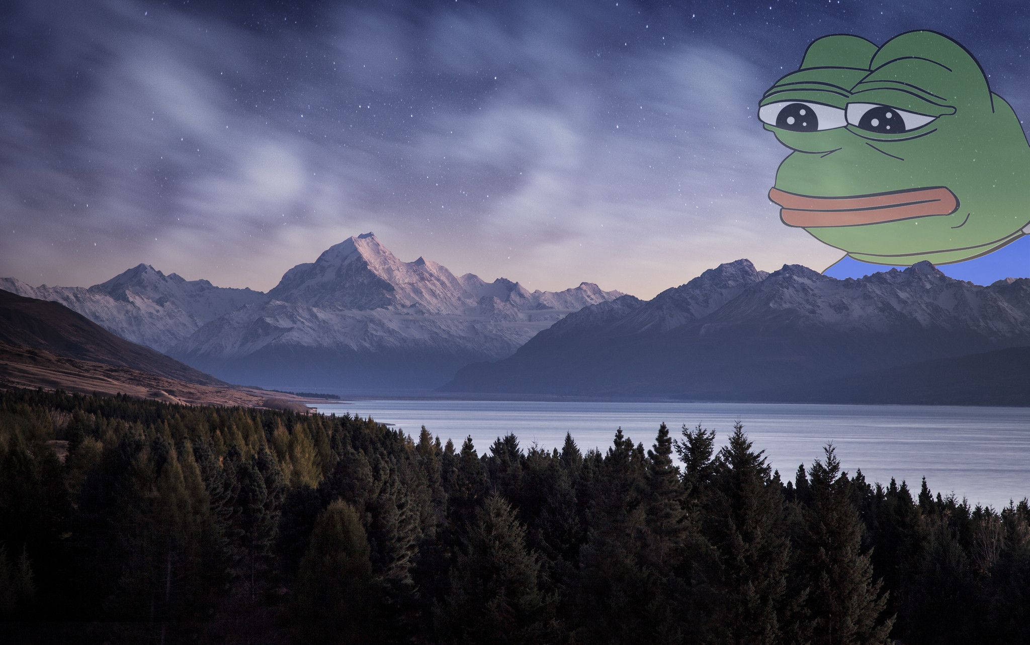 pepe frog 桌布 壁紙 — 星空夜空俯瞰著積雪的山脈和寧靜的湖泊，右上角漂浮著一個巨大的綠色青蛙臉。